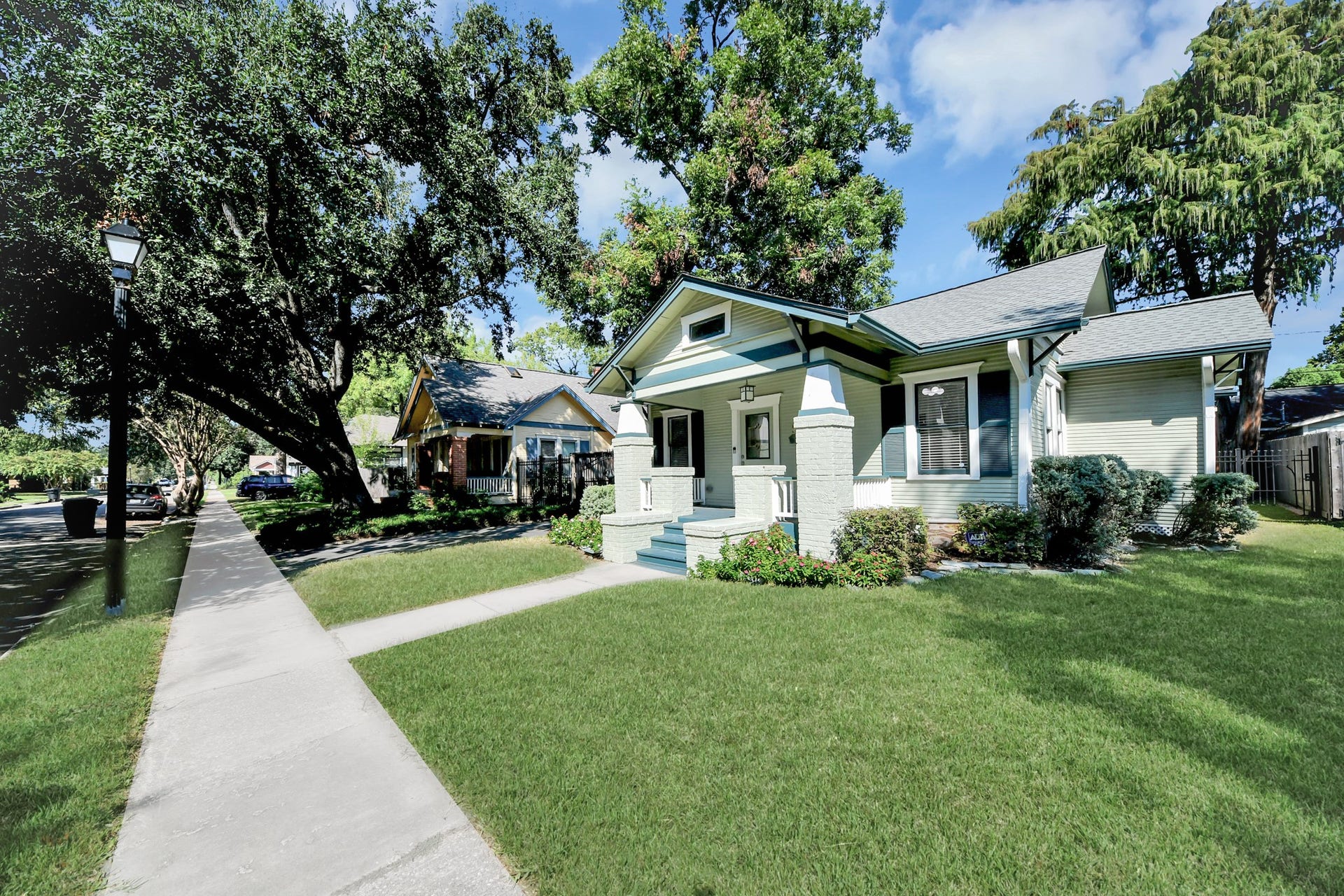 909 Fugate Street, Houston, TX 77009 Charming bungalow with a welcoming front porch, nestled under mature trees on a picturesque street.