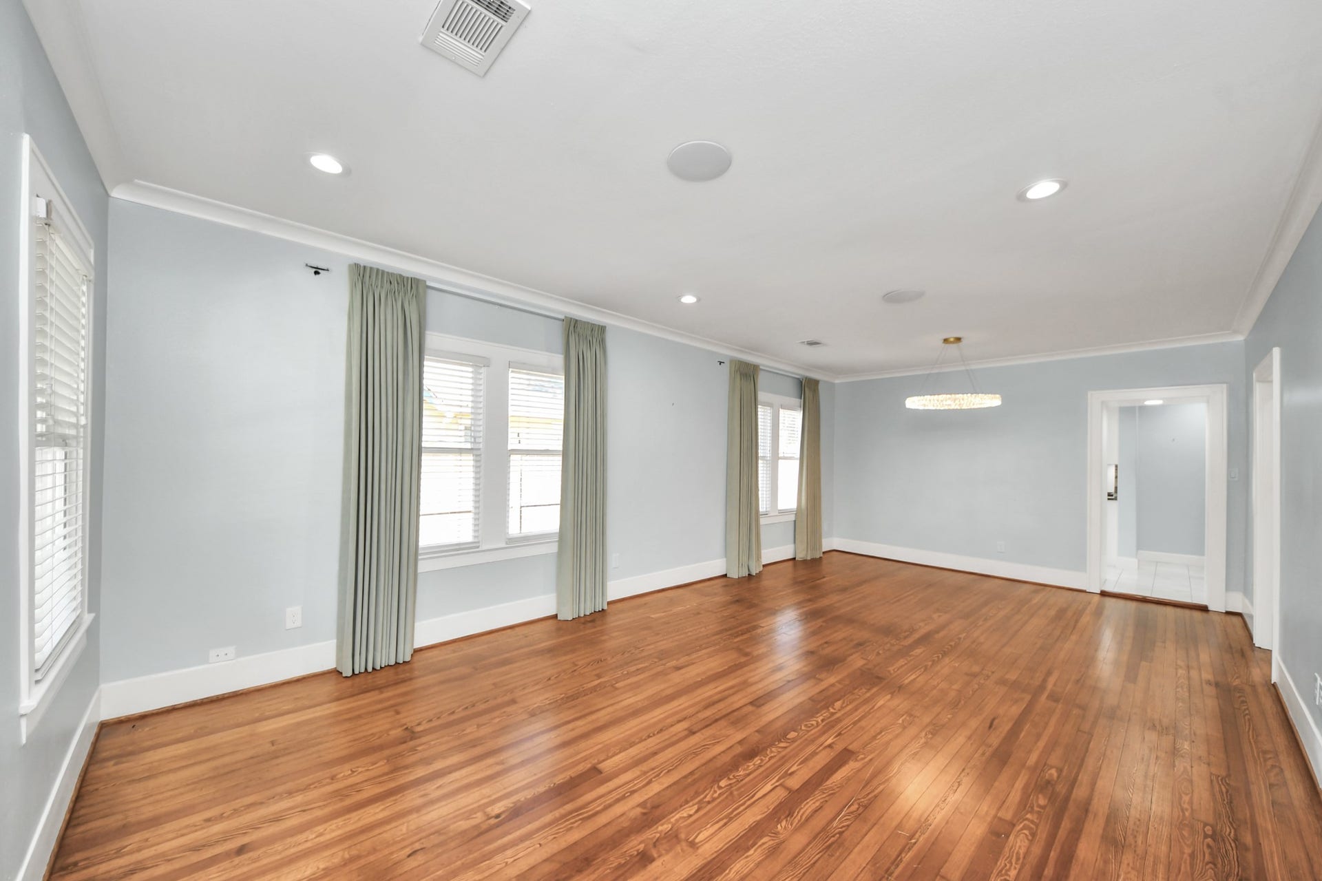 909 Fugate Street, Houston, TX 77009 Spacious living area with gleaming hardwood floors, large windows for natural light, and modern recessed lighting.