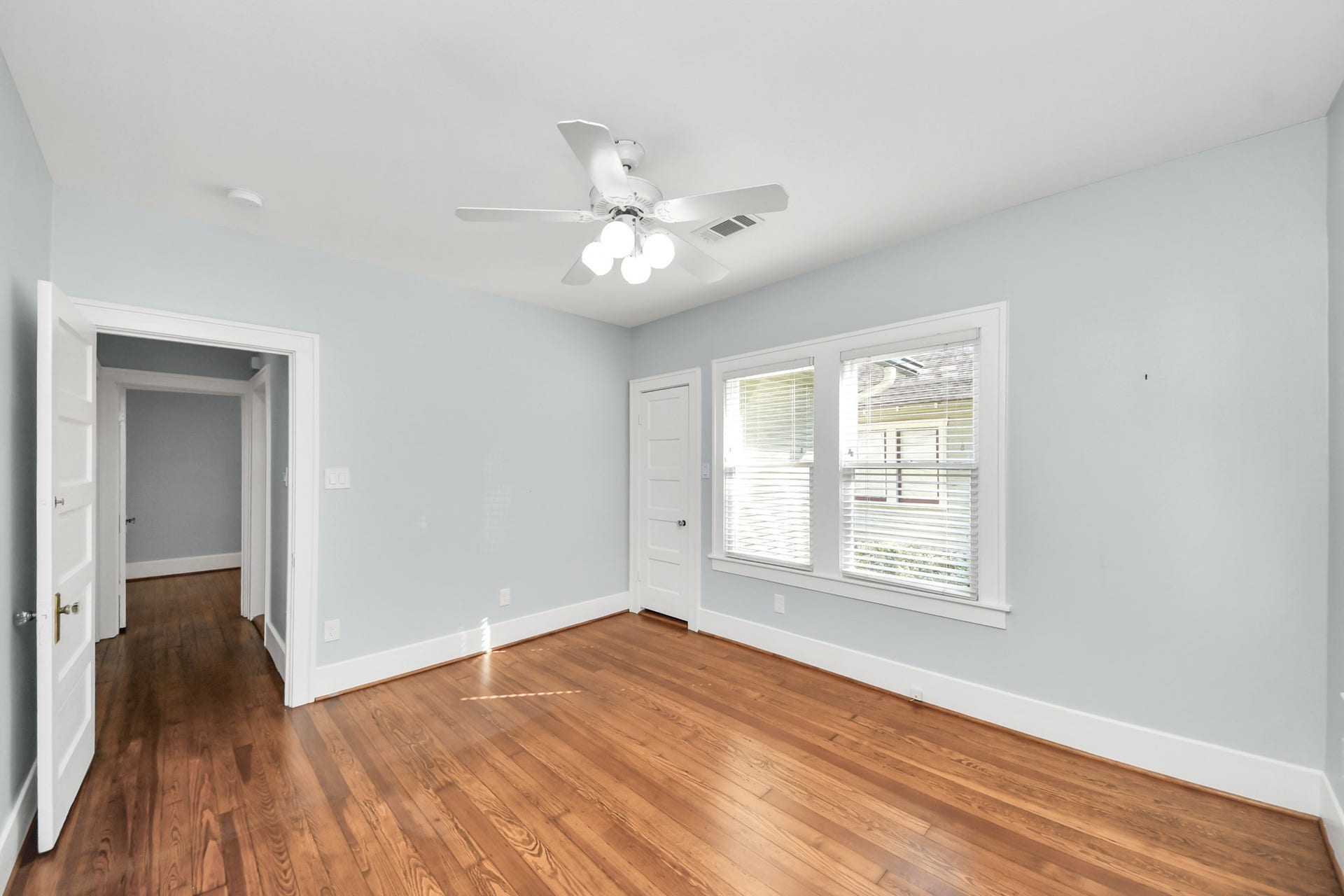 909 Fugate Street, Houston, TX 77009 Bright and inviting, Bedroom 3 offers gleaming hardwood floors, soft blue walls, and ample natural light, creating a serene retreat.