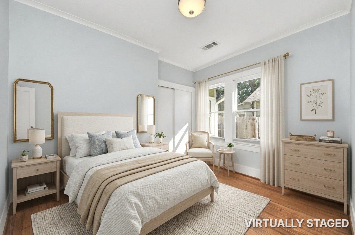 909 Fugate Street, Houston, TX 77009 Bedroom 2: Bright and inviting bedroom with soft blue walls, featuring a cozy bed, elegant furnishings, and ample natural light from large windows.