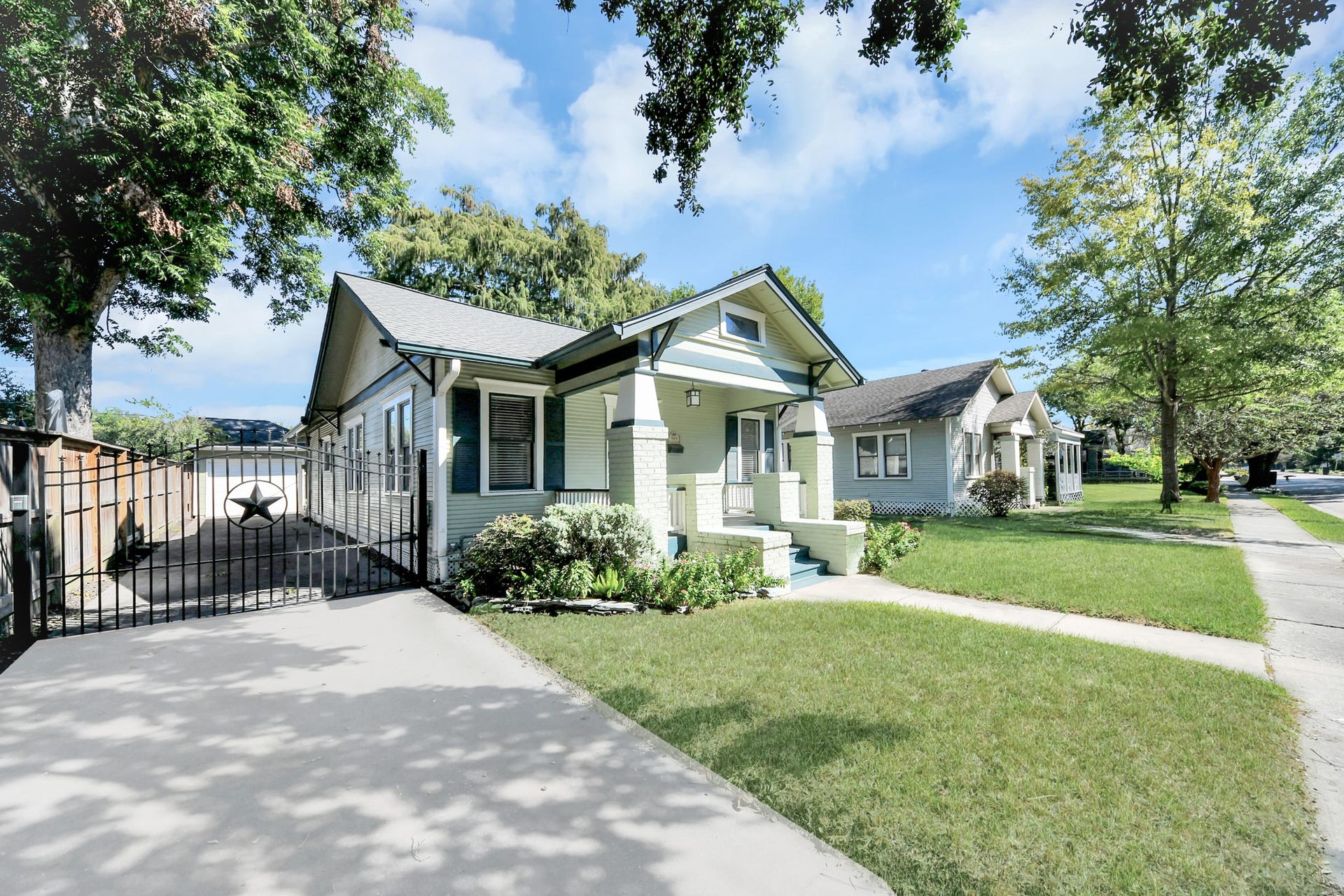 909 Fugate Street, Houston, TX 77009 Charming Craftsman-style home with a welcoming front porch, gated driveway, and lush landscaping on a quiet street.