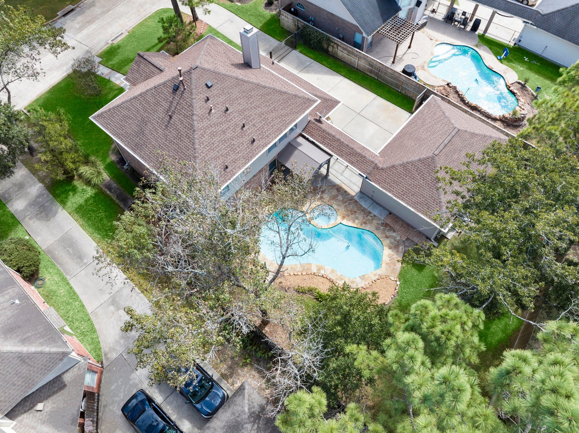 24815 Giltspur Way, Spring, TX 77389 A BIRD'S-EYE VIEW OF PARADISE! Take in the beautiful newer roof, canopy of mature shade trees, and generous lot! A gated driveway leads to the detached 3-car garage, offering added privacy and plenty of parking. The sparkling freeform pool and spa, flagstone decking, and covered outdoor entertaining area complete this backyard oasis. SO MUCH TO LOVE FROM EVERY ANGLE!