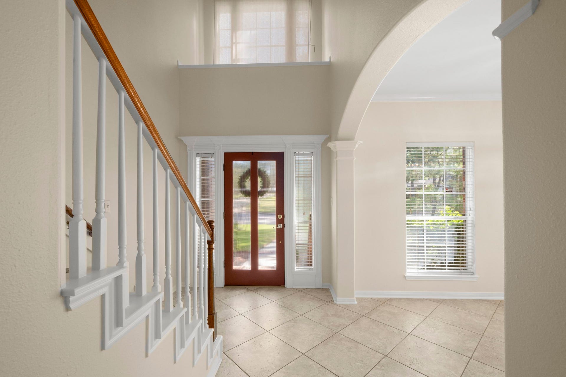 24815 Giltspur Way, Spring, TX 77389 SOARING CEILINGS & TIMELESS ARCHITECTURAL CHARM! This impressive 19-foot, two-story foyer makes a grand first impression with abundant natural light pouring through the elevated window and flanking sidelights. A decorative display ledge, graceful arched opening, elegant staircase with wood handrail, and easy-care tile flooring create a bright, welcoming entry filled with character!