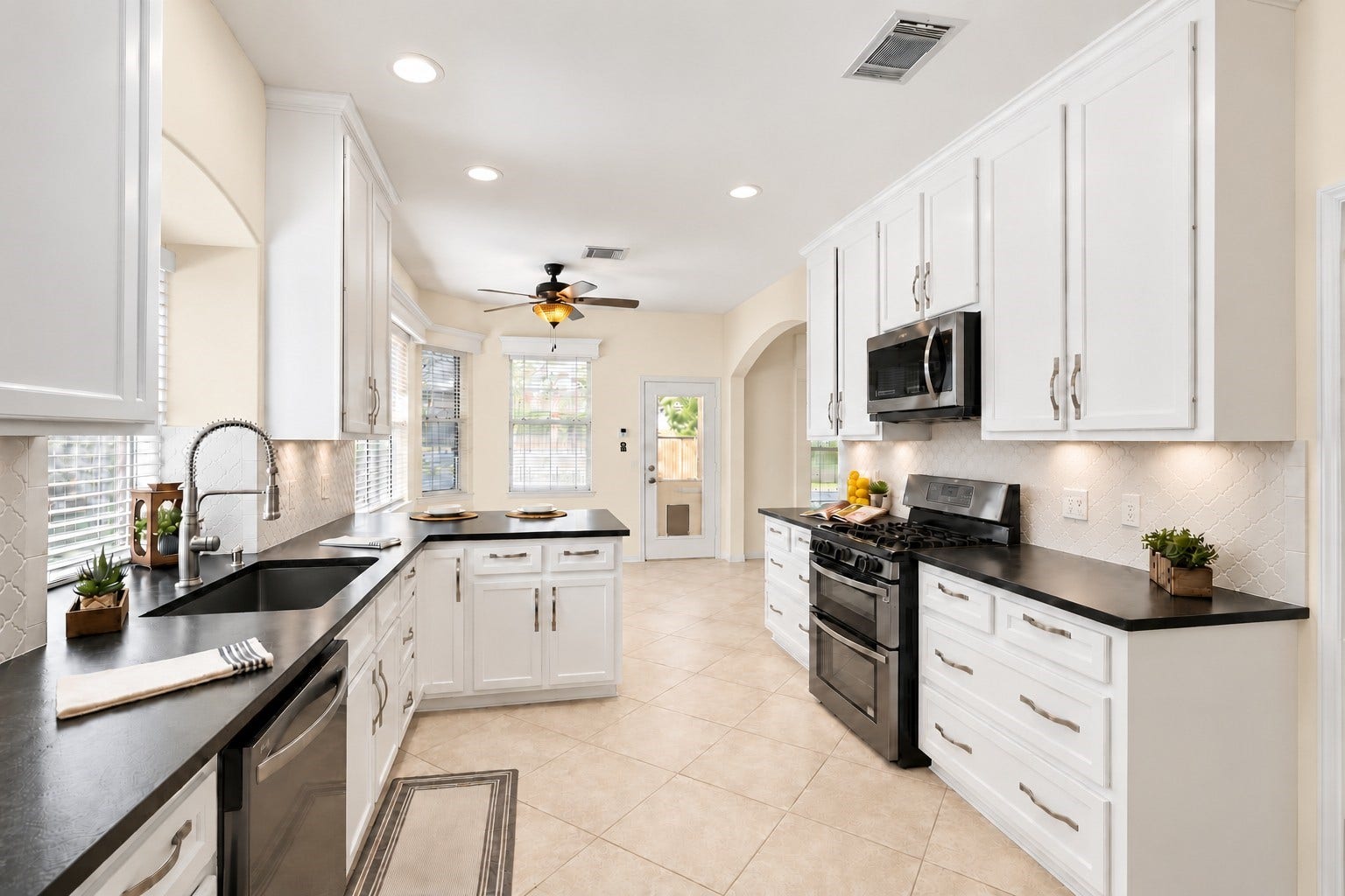 24815 Giltspur Way, Spring, TX 77389 NOT YOUR ORDINARY KITCHEN! Thoughtfully reimagined with an extensive custom renovation, this gorgeous kitchen features handcrafted white cabinetry extending to the ceiling, stunning leathered quartz countertops with custom ogee-edge detailing, a beautiful gray arabesque tile backsplash, and sleek black stainless appliances. A deep undermount sink with professional-style pull-down faucet, recessed lighting, and abundant custom storage make this kitchen as functional as it is beautiful!