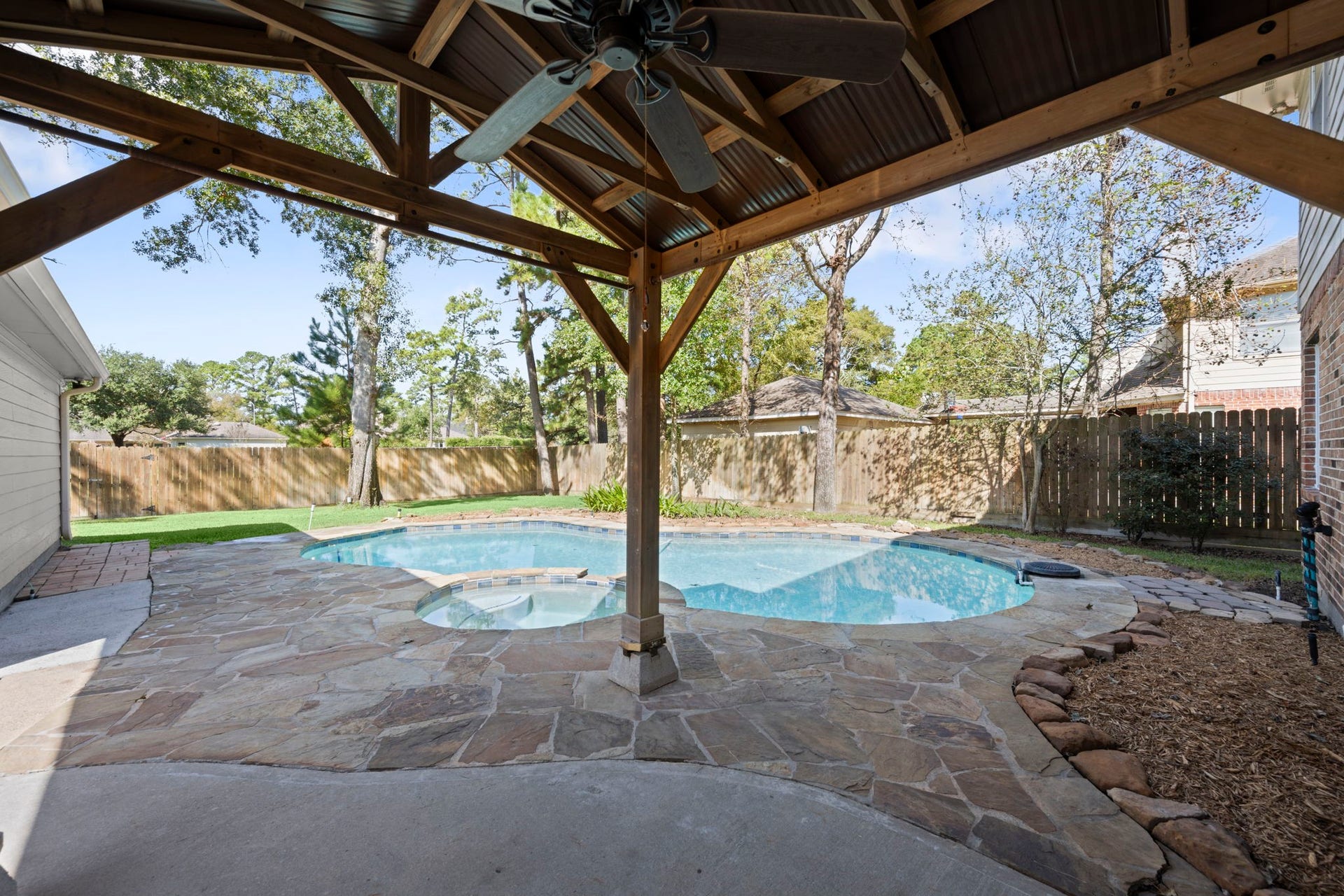 24815 Giltspur Way, Spring, TX 77389 OUTDOOR ENTERTAINING AT ITS FINEST! This charming timber-framed gazebo features a ceiling fan, electricity, and a shaded retreat for dining alfresco or enjoying evenings under the stars! Just steps from the kitchen, entertaining is effortless. Gorgeous flagstone decking surrounds the sparkling freeform pool with its inviting curved edges and adjoining spa. From morning coffee to sunset cocktails and poolside gatherings, this backyard was made for making memories!