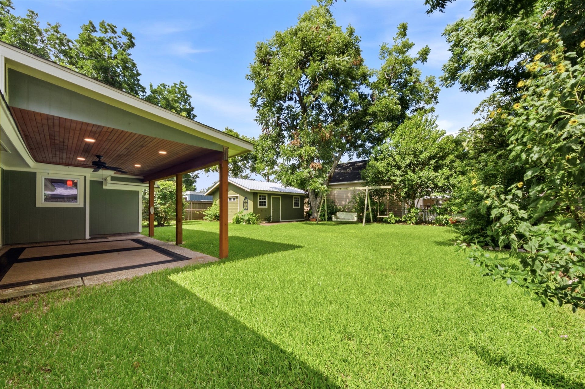 410 Kyle Street, Sugar Land, TX 77478 The backyard extends well beyond the patio, creating plenty of open green space beneath the shade of mature trees.