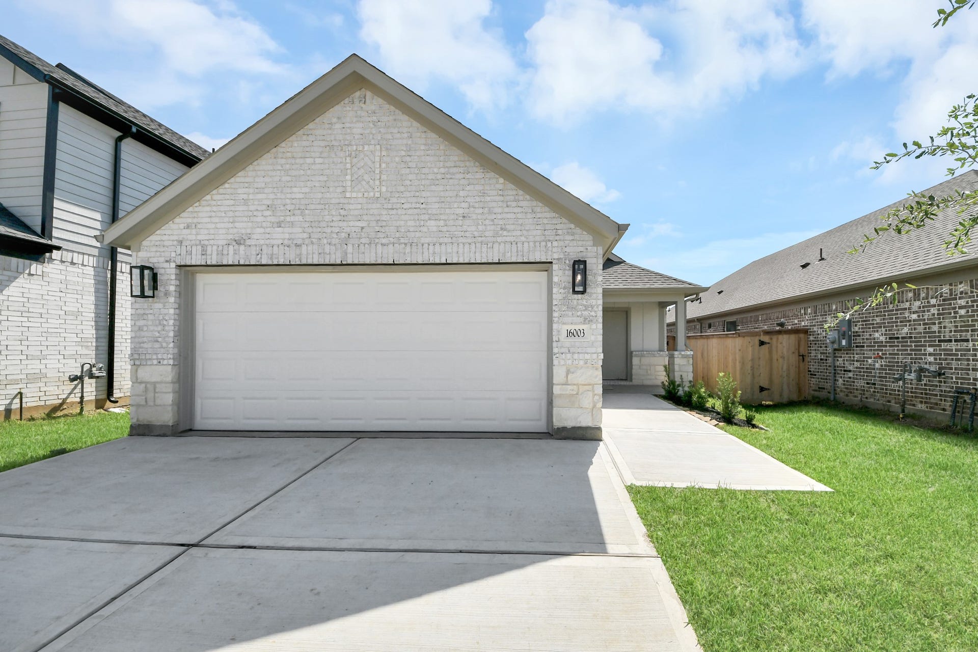 16003 Sycamore Maple Lane, Cypress, TX 77429 Meticulously maintained yard and lush landscape, paired with a premium elevation featuring captivating brick accents. Modern coach lights add a touch of contemporary elegance to the exterior.
