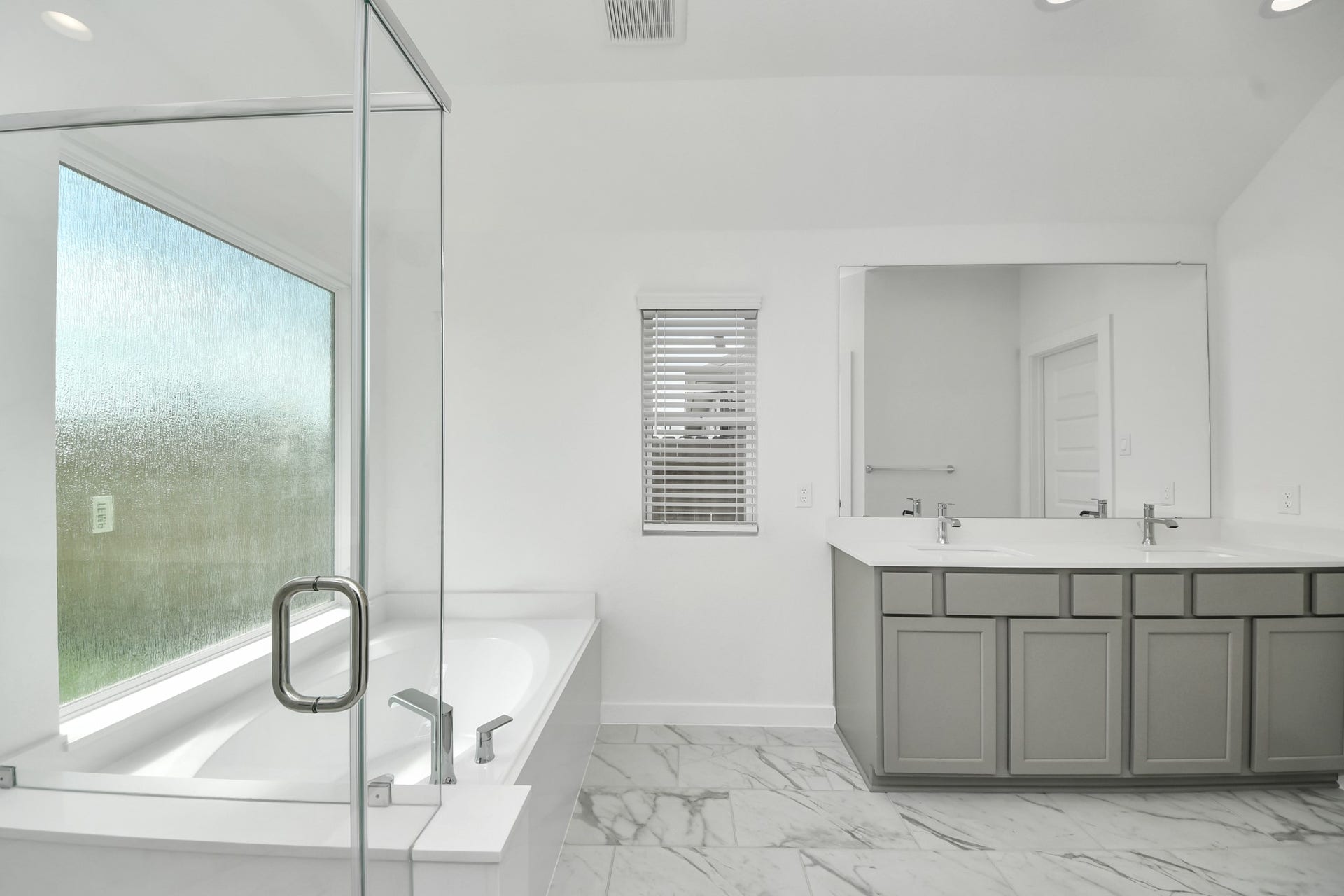 16003 Sycamore Maple Lane, Cypress, TX 77429 Indulge in a spa-like retreat within the confines of this primary bathroom. Delight in a spacious walk-in shower enveloped in stylish tile surround, unwind in a separate garden tub adorned with custom detailing.