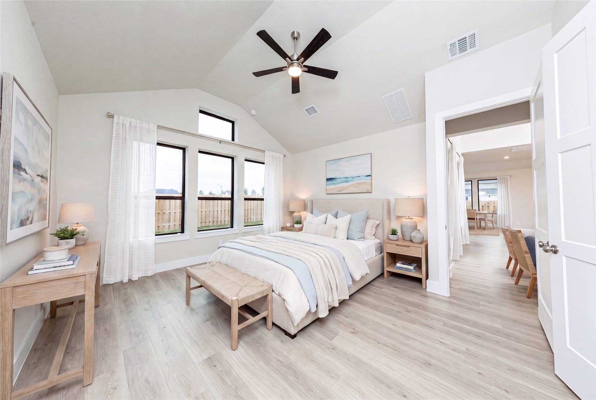 Relax and unwind after a long day in this impressive primary suite! This generously sized room offers laminate flooring, neutral-toned paint, high ceilings with a ceiling fan, and large windows for added comfort and tranquility. *Virtually Staged