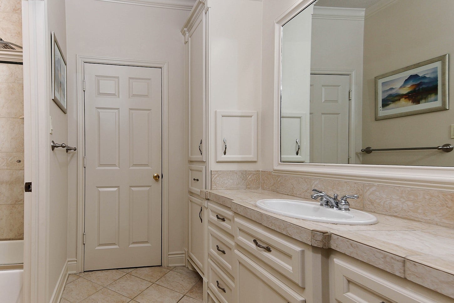 10 Snow Pond Place, The Woodlands, TX 77382 The Jack-and-Jill bathroom features dual vanity areas and a shared central space containing the tub, shower, and water closet.