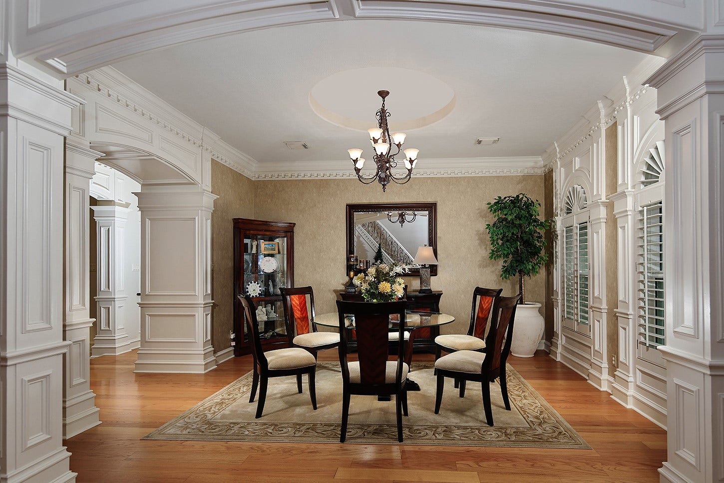 10 Snow Pond Place, The Woodlands, TX 77382 The formal dining room features elegant paneling and graceful arched openings, creating a sophisticated atmosphere perfect for both intimate family dinners and refined entertaining.