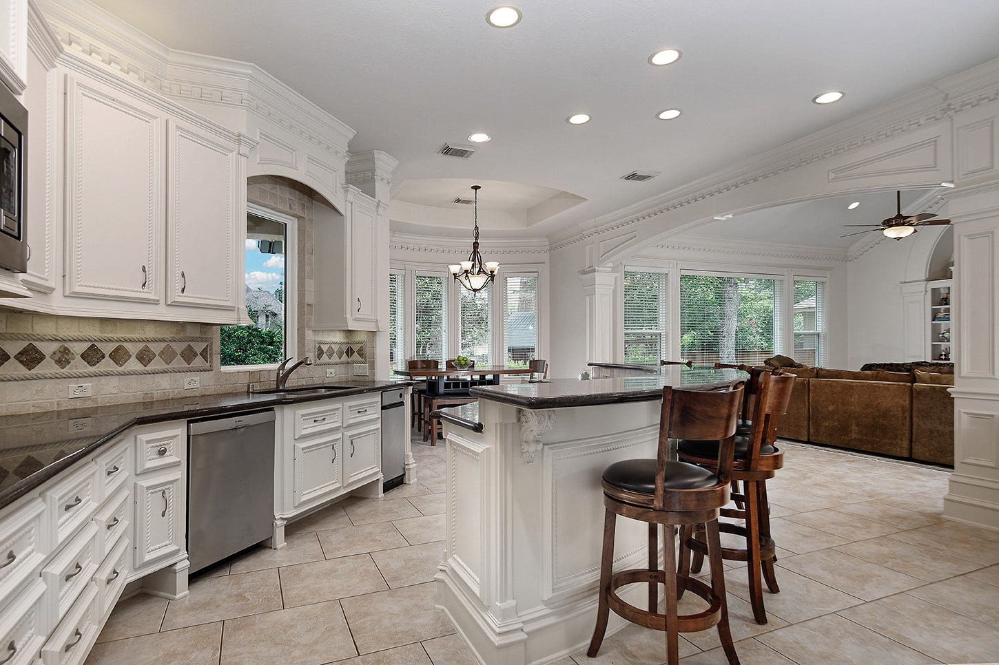 10 Snow Pond Place, The Woodlands, TX 77382 The tile flooring perfectly complements the custom tile backsplash, while the expansive counter and cabinet space provide ample room for meal preparation and storage.