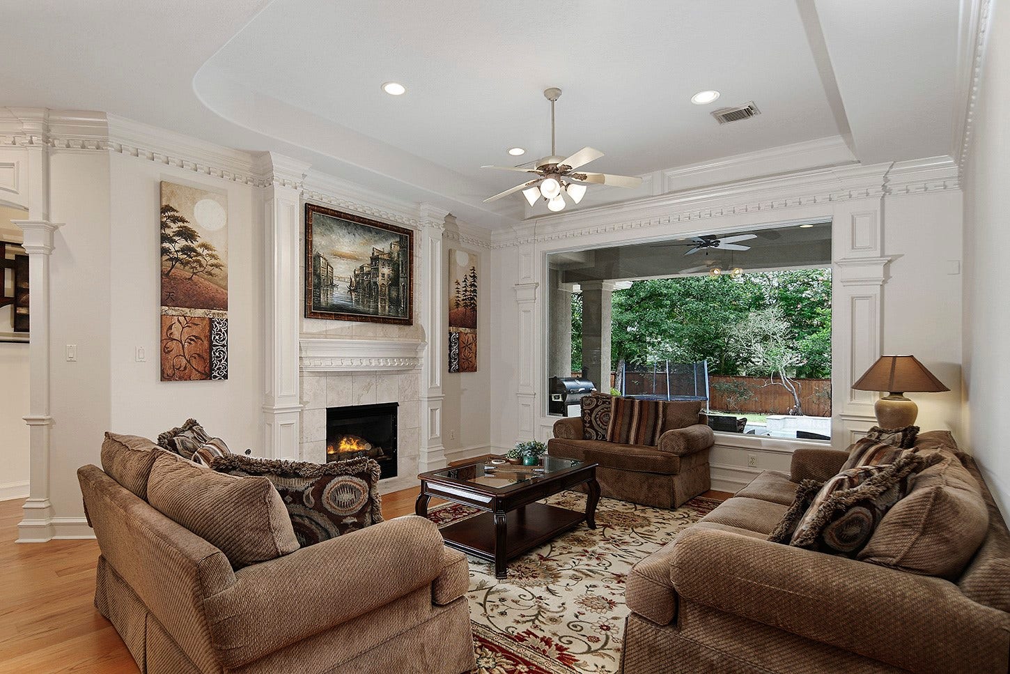 10 Snow Pond Place, The Woodlands, TX 77382 This formal living room features elegant crown molding and a expansive plate glass window offering picturesque views of the swimming pool. The sophisticated fireplace enhances the inviting ambiance of this spacious area to relax, enjoy conversation, or read a book.