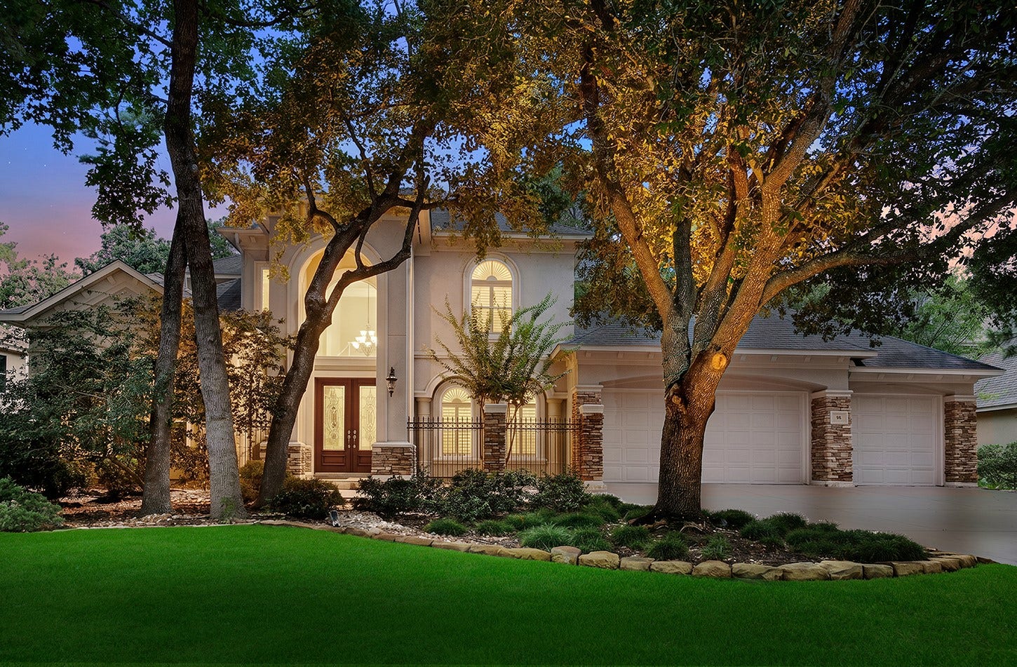 10 Snow Pond Place, The Woodlands, TX 77382 The property features meticulously maintained landscaping, mature oak trees, and a sophisticated stucco and stone facade, offering exceptional curb appeal. This residence is further complemented by an integrated three-car garage, providing both aesthetic appeal and practical functionality for the modern family.