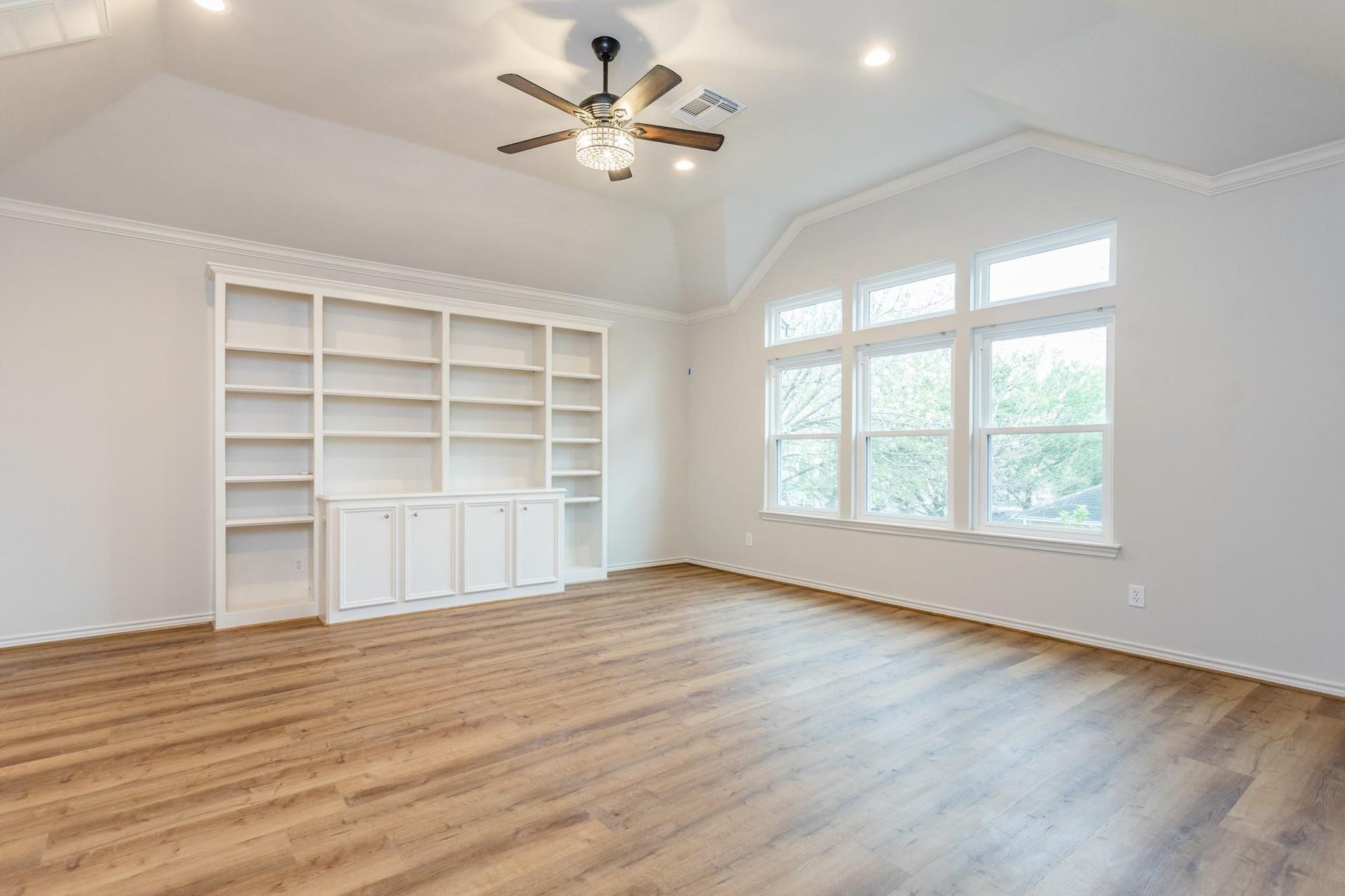 Primary bedroom boasts ample natural lighting and custom built-ins.