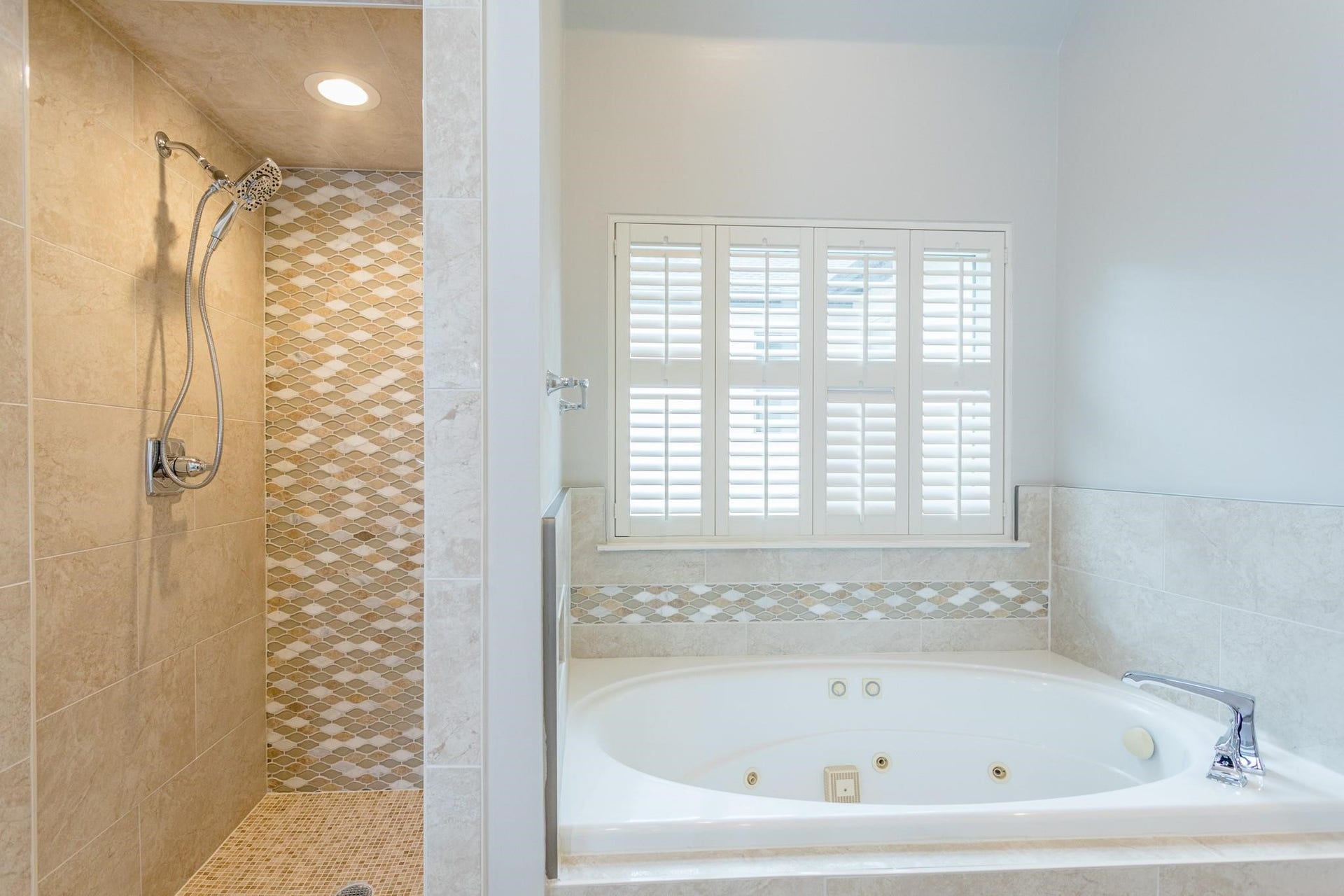 Primary bathroom equipped with a standing shower and separate jetted soaking tub.