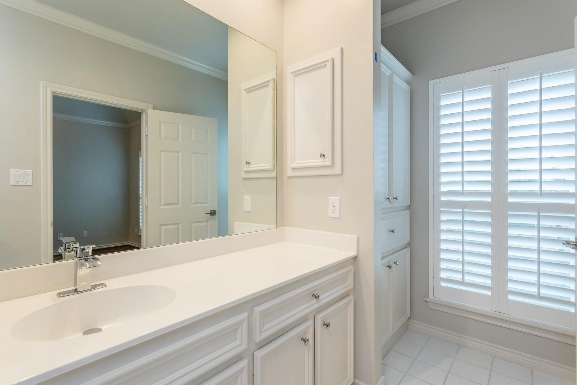 Additional sink in secondary bathroom, with more cabinetry for storage.