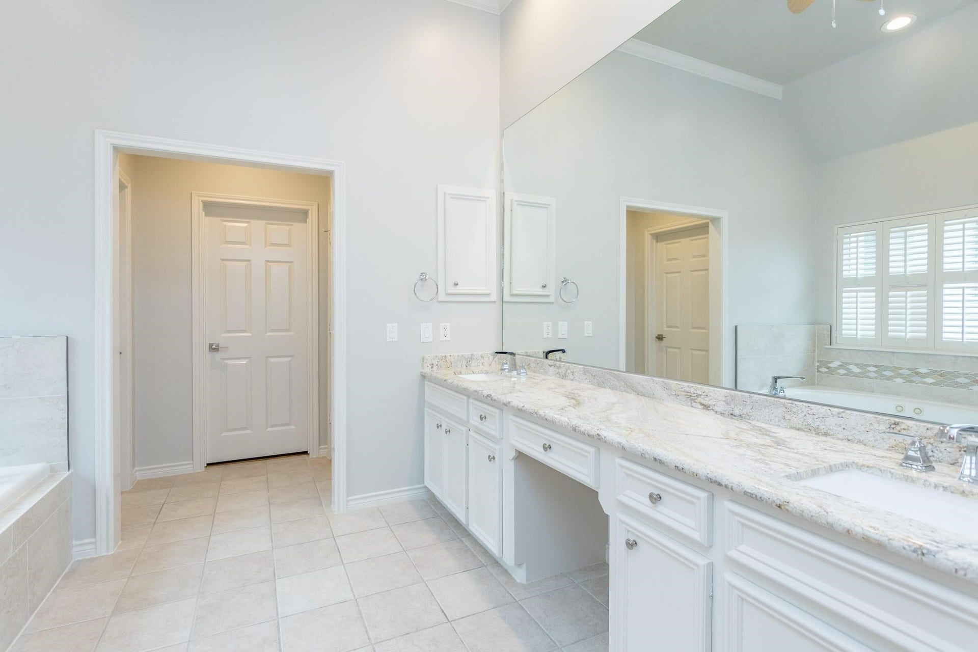 Primary ensuite bathroom with dual vanity sinks.