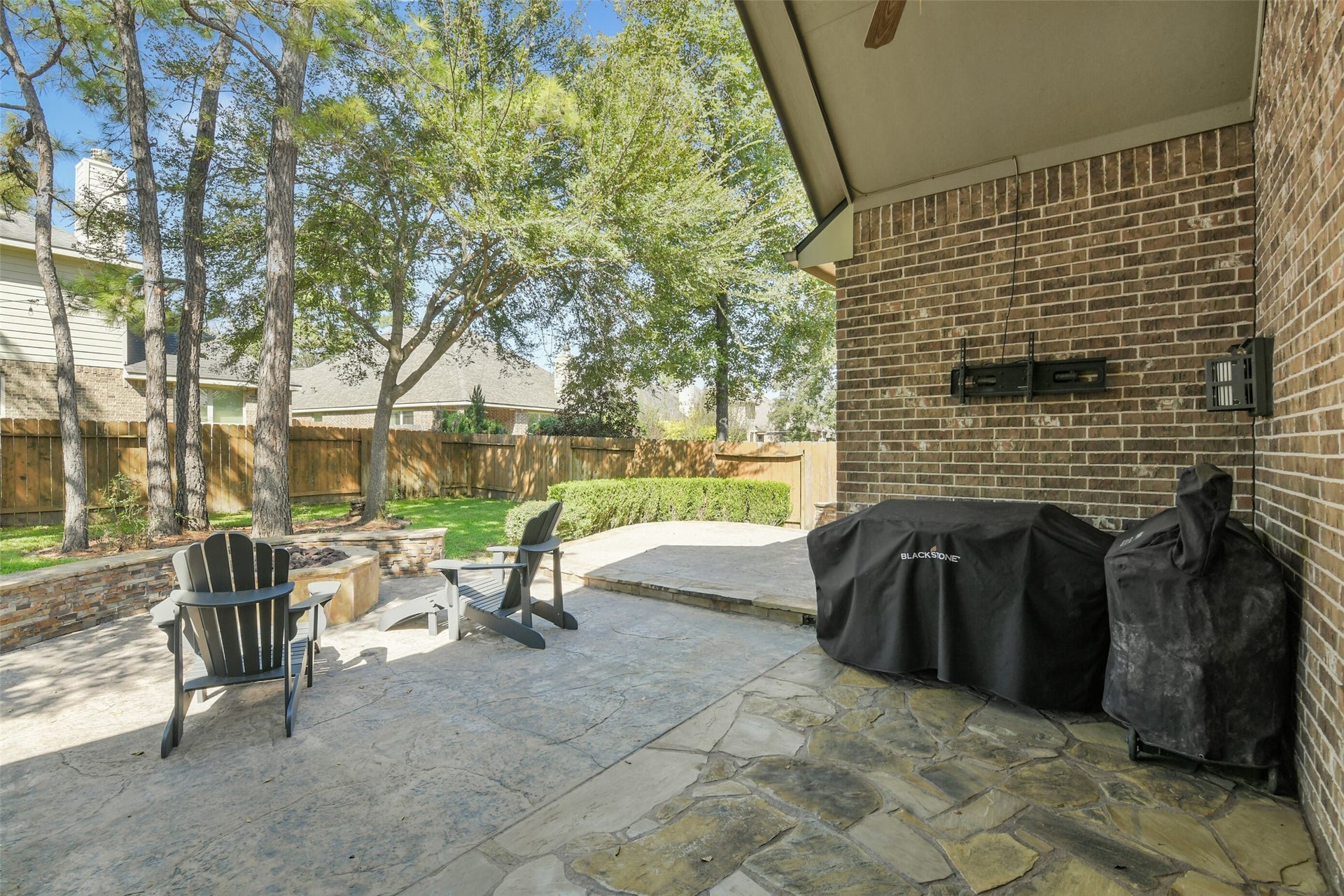 119 Finchfield Place, Montgomery, TX 77316 Covered outdoor living area with brick fireplace, providing a wonderful setting for year-round entertaining.