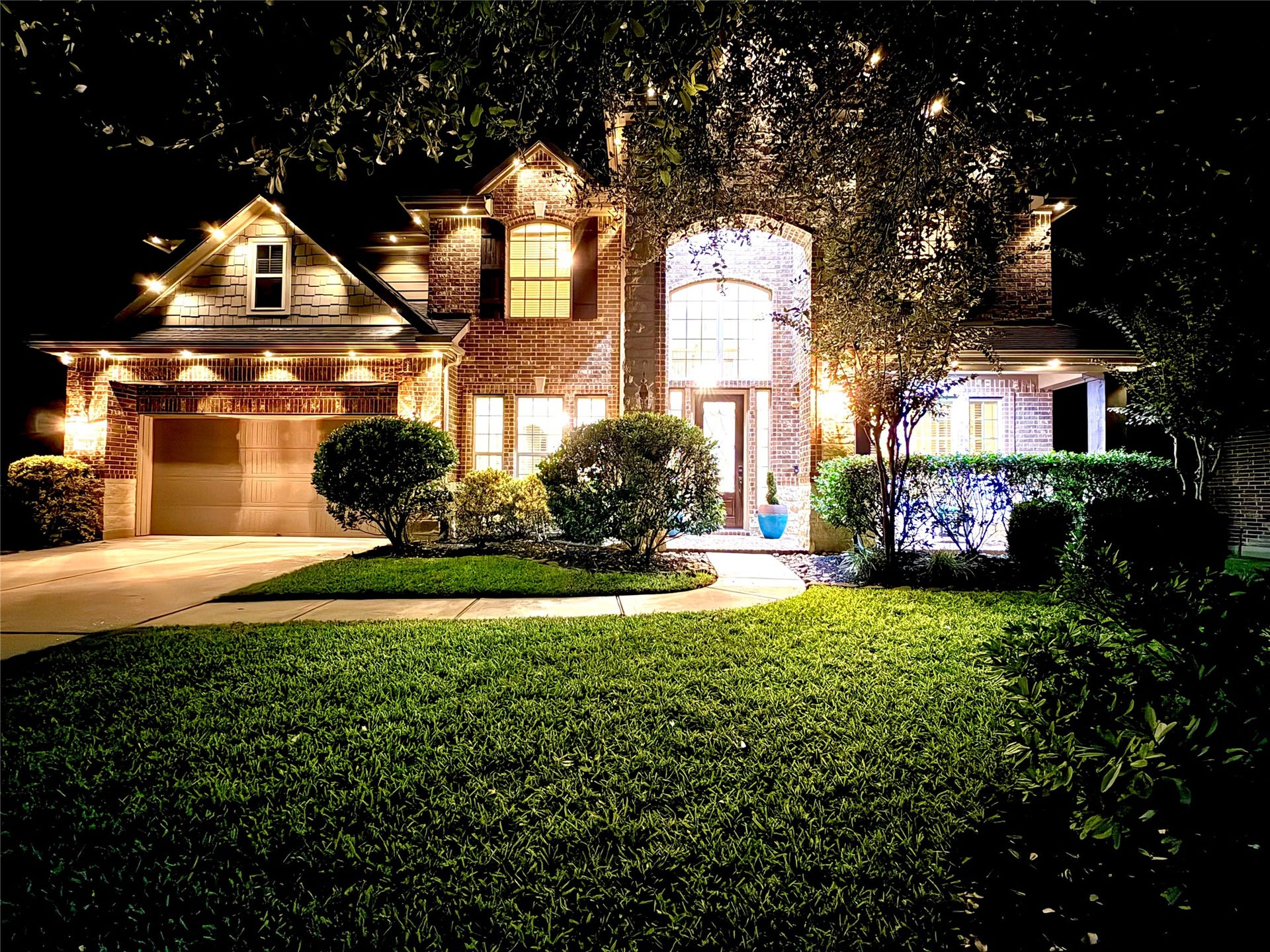 119 Finchfield Place, Montgomery, TX 77316 Stunning twilight view of this beautiful brick and stone home, showcasing dramatic exterior lighting
