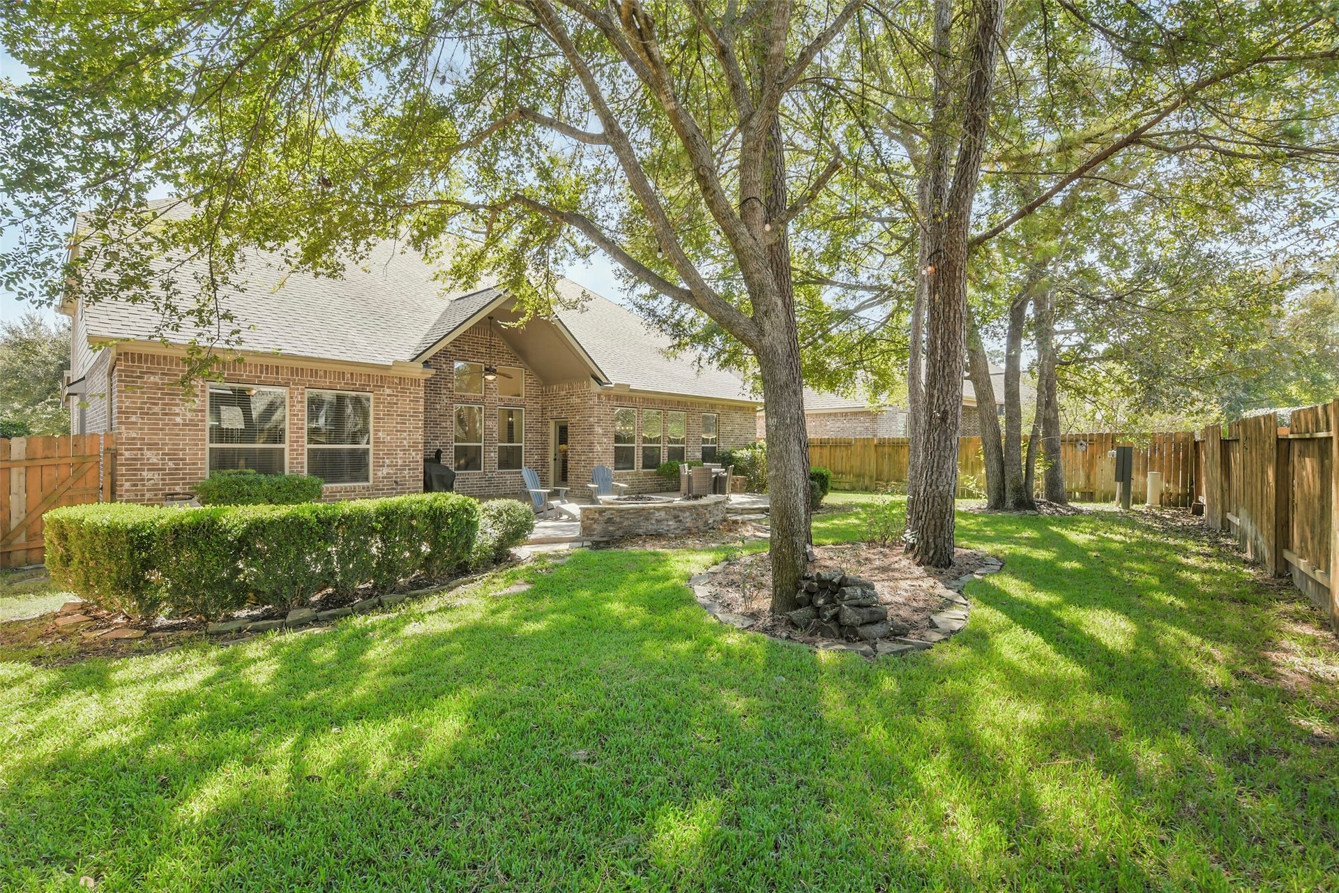 119 Finchfield Place, Montgomery, TX 77316 Beautifully landscaped backyard with lush green lawn, mature trees, and privacy fencing.