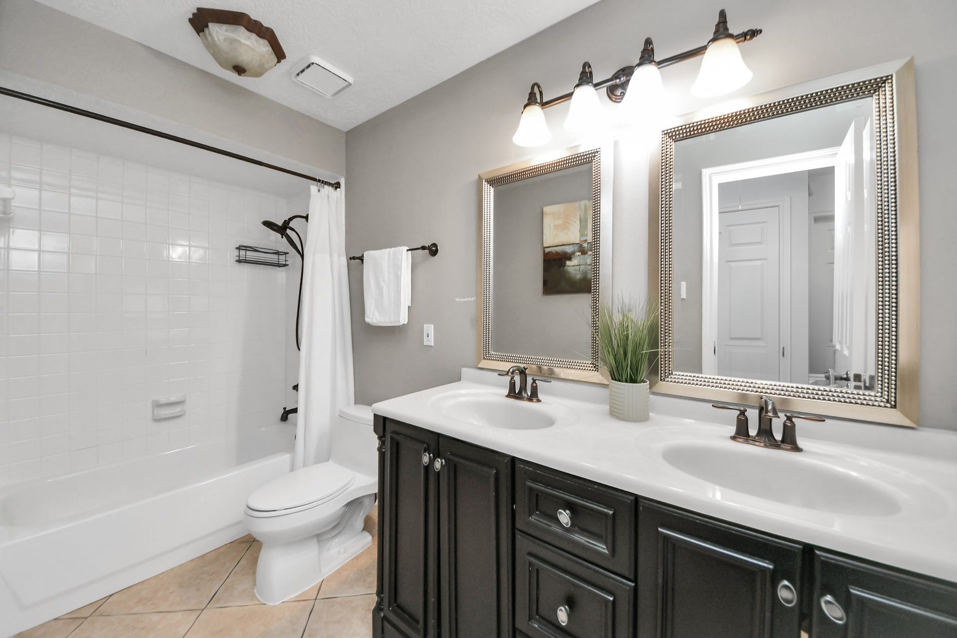 The secondary bathroom features two sinks, plenty of cabinet storage, and a tub and shower combination.