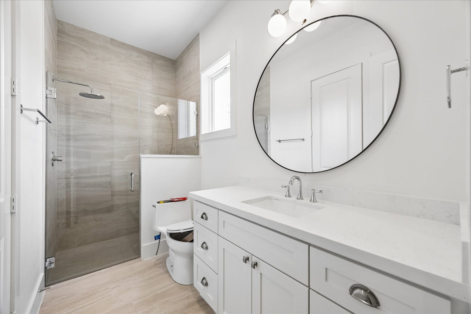 1726 Chantilly Lane, Houston, TX 77018 A glass-enclosed shower and vanity define this full bathroom. The tiled shower and coordinated fixtures carry the homes detailed finish selections into the secondary spaces.