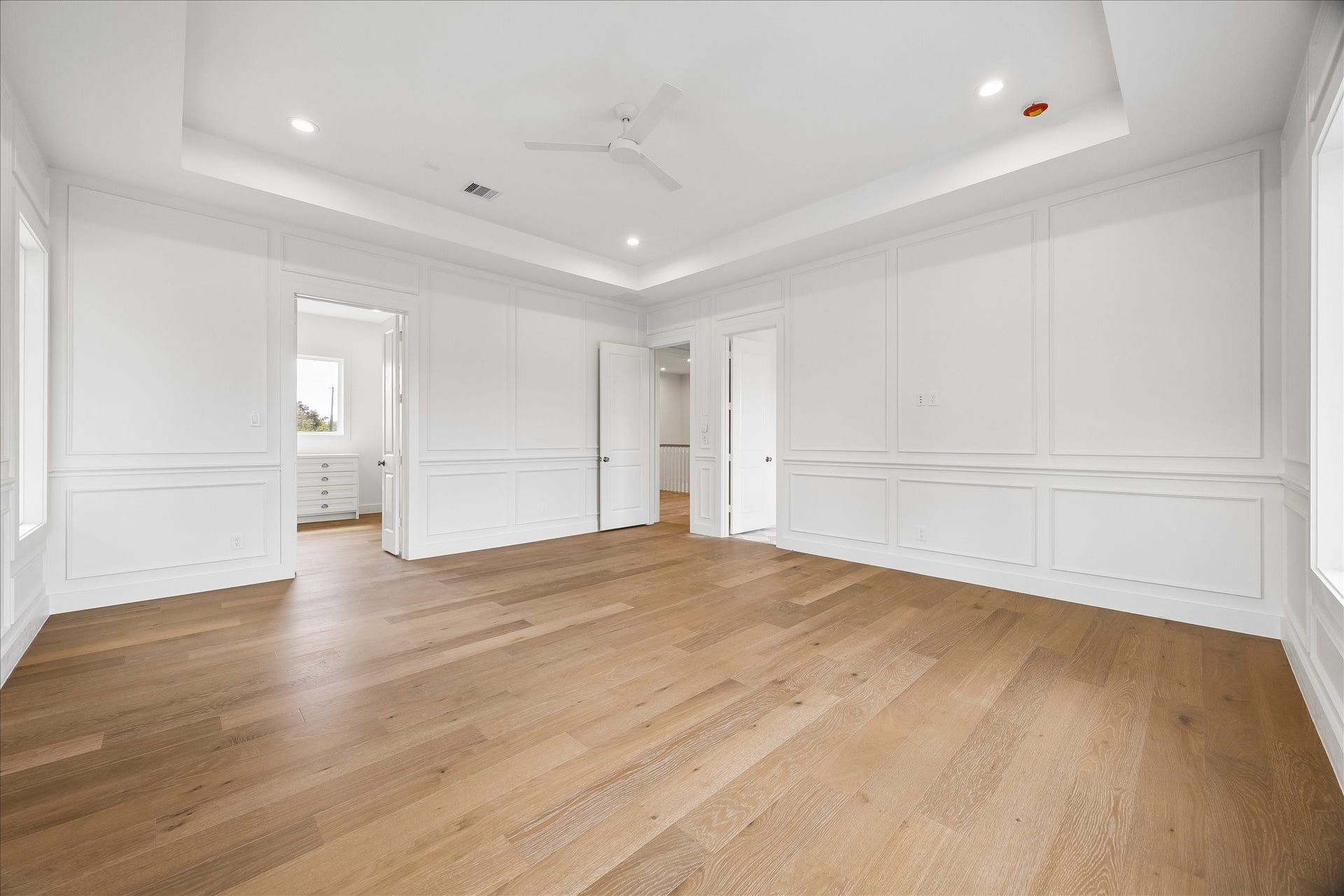 1726 Chantilly Lane, Houston, TX 77018 This angle shows the primary bedrooms connection to the adjoining suite spaces. Wood flooring and paneled detailing continue throughout the room.