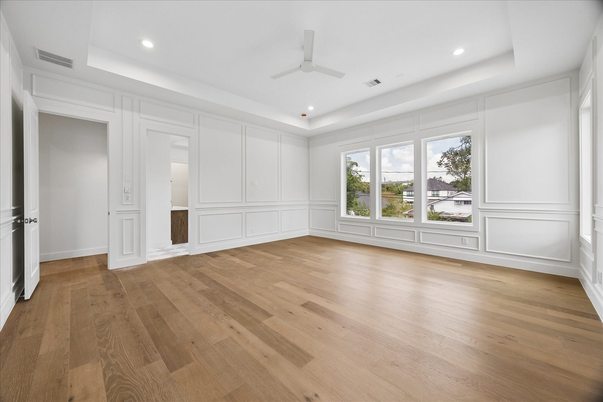 1726 Chantilly Lane, Houston, TX 77018 An alternate view of the primary bedroom highlights its generous floor area and natural light. The simple wall palette allows the ceiling and paneling details to stand out.