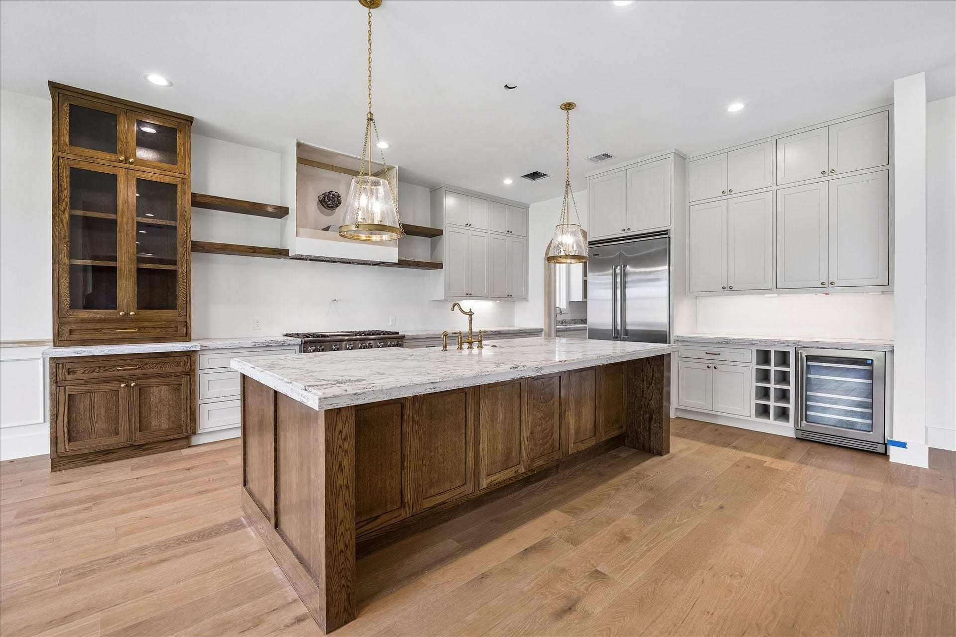 1726 Chantilly Lane, Houston, TX 77018 The kitchen island offers a generous work surface and seating space. Wood accents, glass-front cabinetry and a beverage cooler add detail and useful storage around the room.
