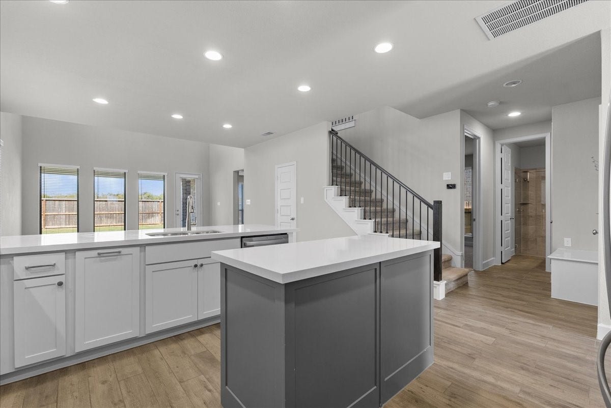 19007 Satsuma Ridge Drive, Manvel, TX 77578 View of the kitchen and on the right of the stairs is the guest bedroom/bathroom downstairs.