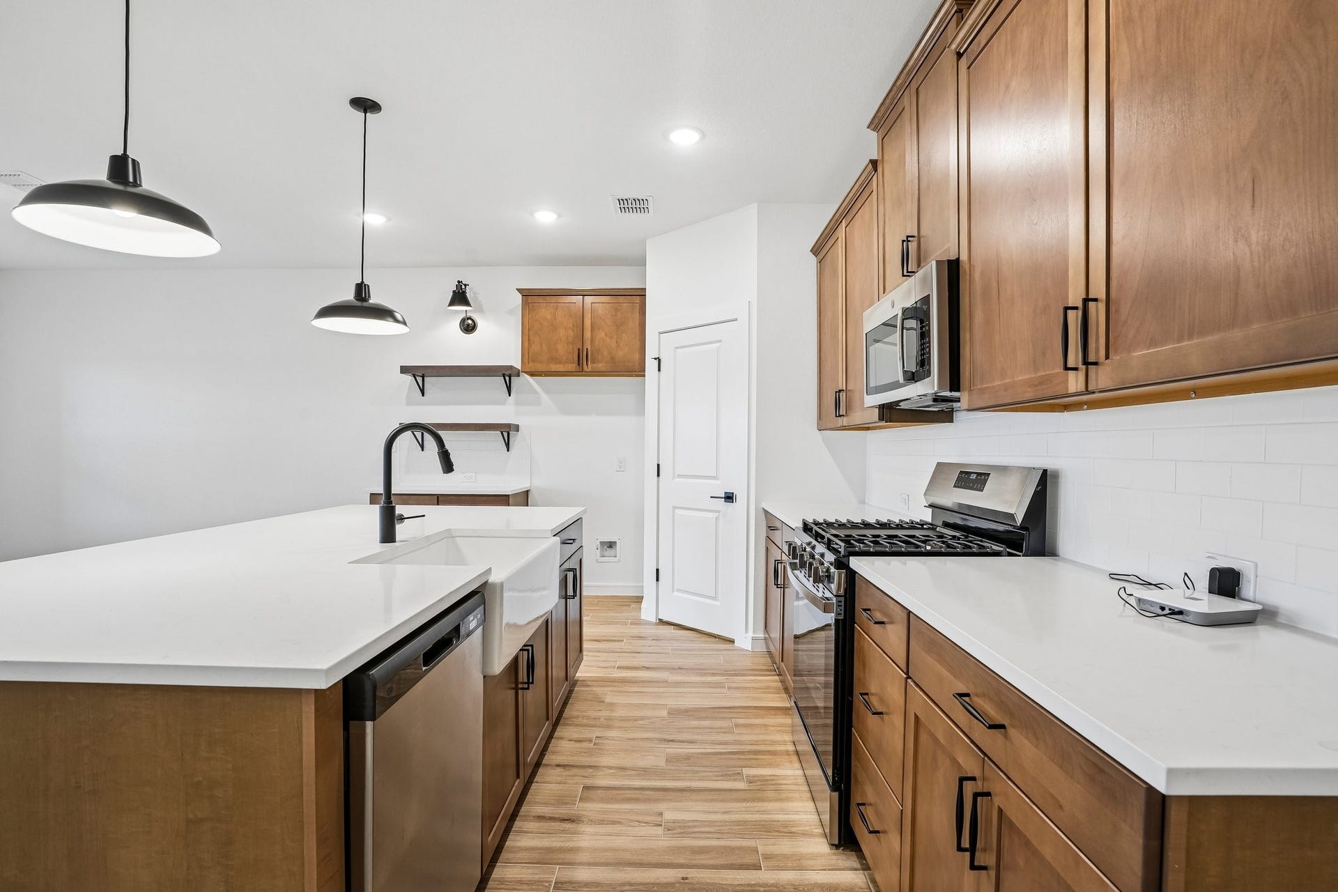 Gorgeous kitchen with chestnut brown cabinets and quartz counters