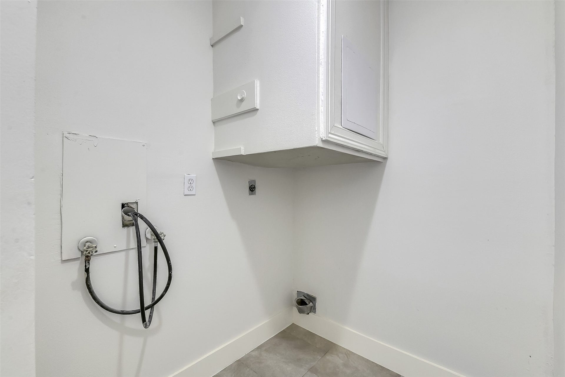 A dedicated laundry area keeps laundry out of the main living spaces, with cabinetry above for extra storage