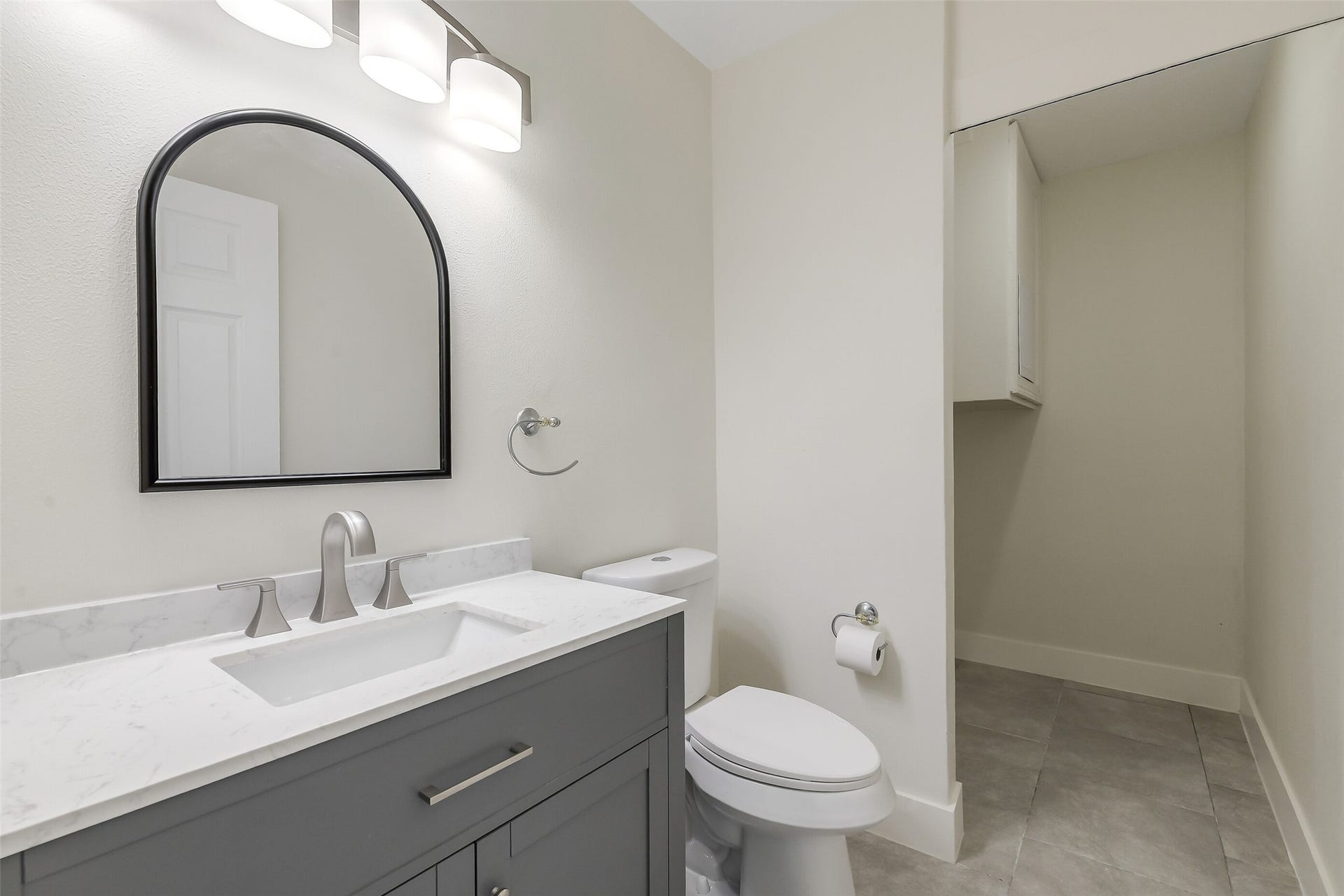 A refreshed half bath with a little bonus extra space beyond the vanity adding storage right where you need it