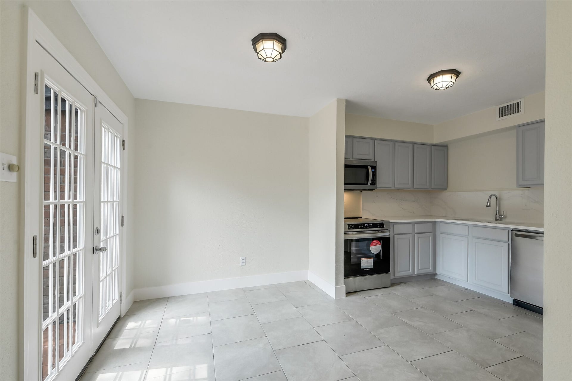 French doors bring sunlight into the kitchen and make outdoor dining just a few steps away