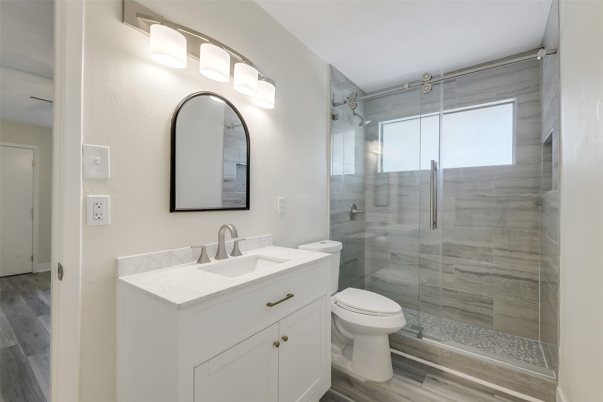 One of the standout renovations: a redesigned primary bath with a large tiled shower and frameless glass enclosure