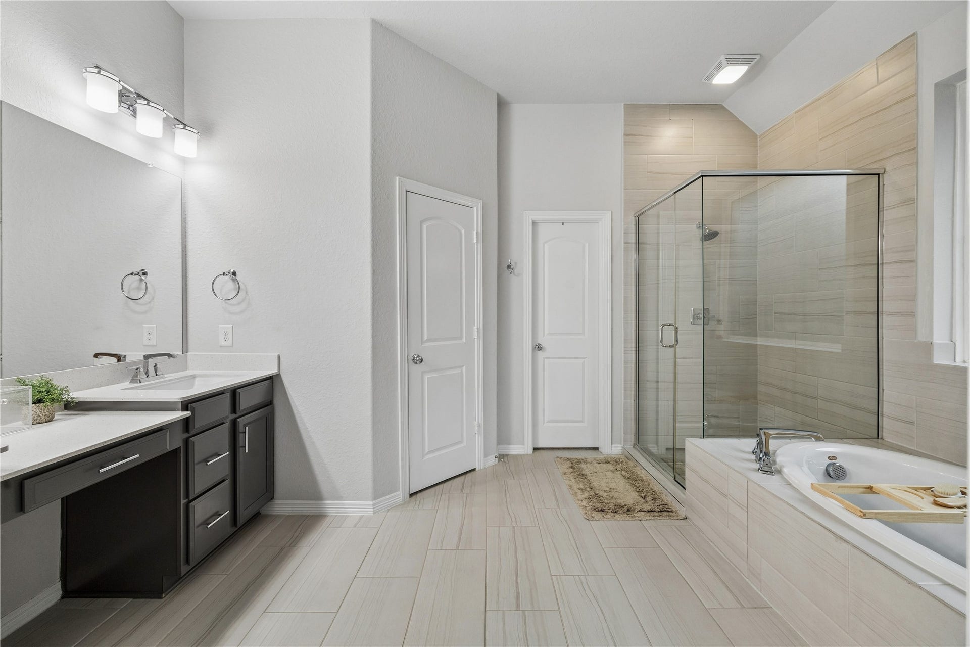14231 Archer County Trail, Cypress, TX 77429 primary bath, dual quartz counters, vanity, organic tone porcelain tile floors, framed shower, large drop in tub.