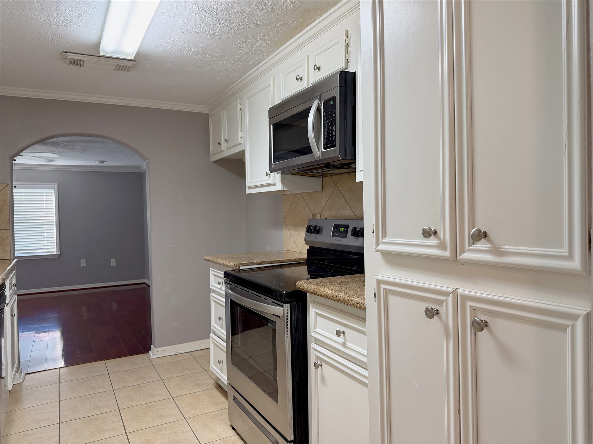 1302 N Avenue R, Freeport, TX 77541 Functional galley kitchen features a streamlined design with ample workspace and easy access between the cooking, prep, and storage areas.