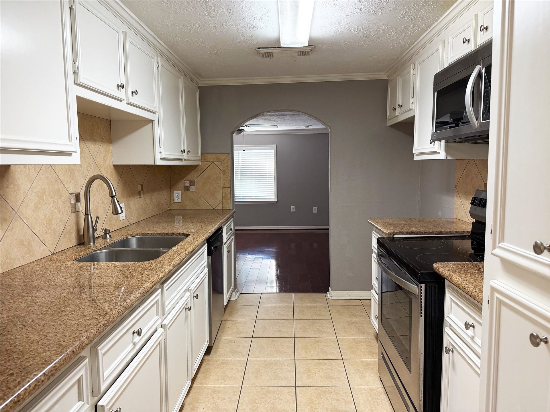 1302 N Avenue R, Freeport, TX 77541 Galley-style kitchen offers an efficient layout with cabinetry and counter space along both sides for convenient meal preparation and storage.