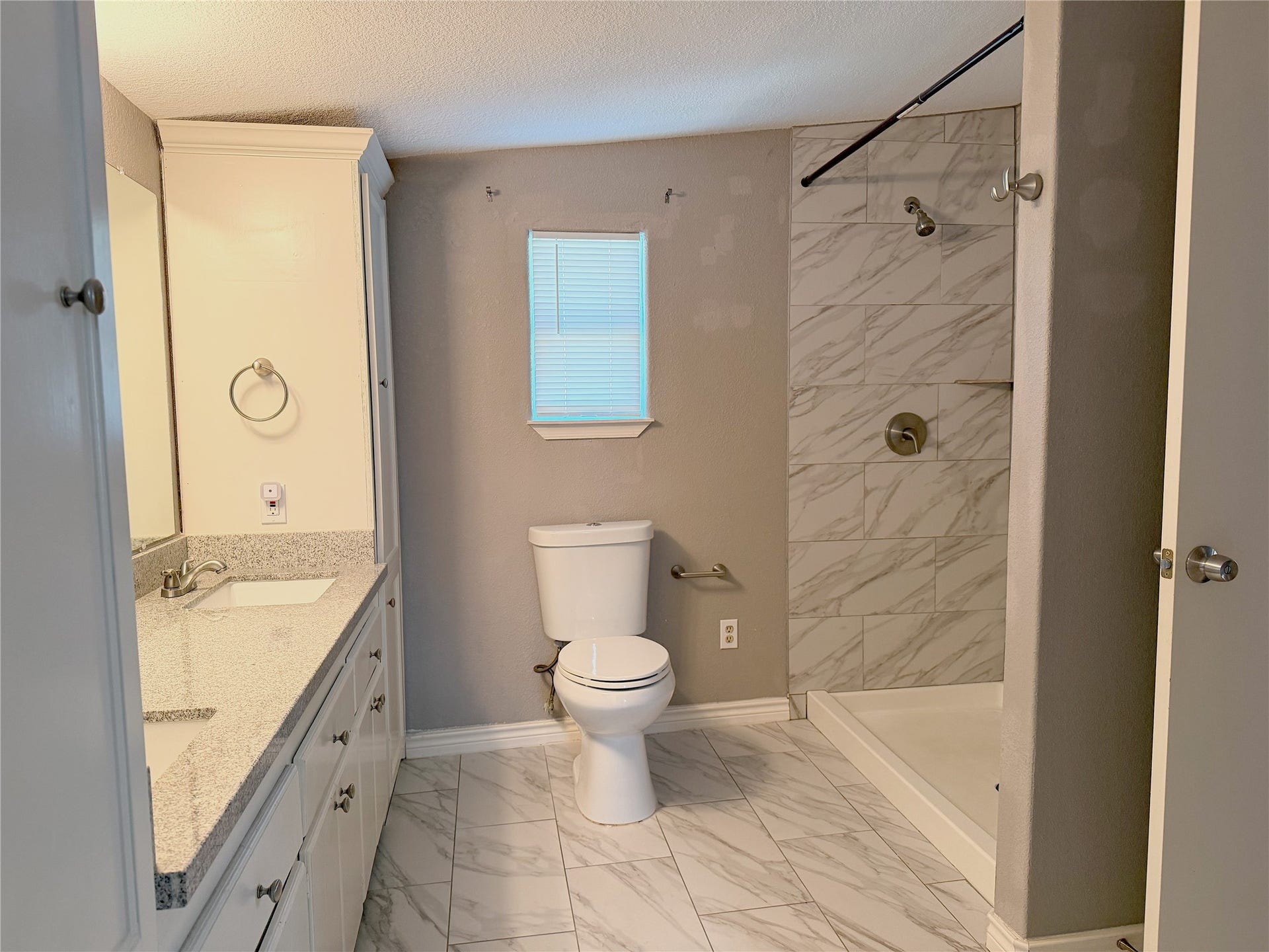 1302 N Avenue R, Freeport, TX 77541 Primary bathroom features a stand-up shower, double sinks, and a functional layout with space for everyday storage and use.