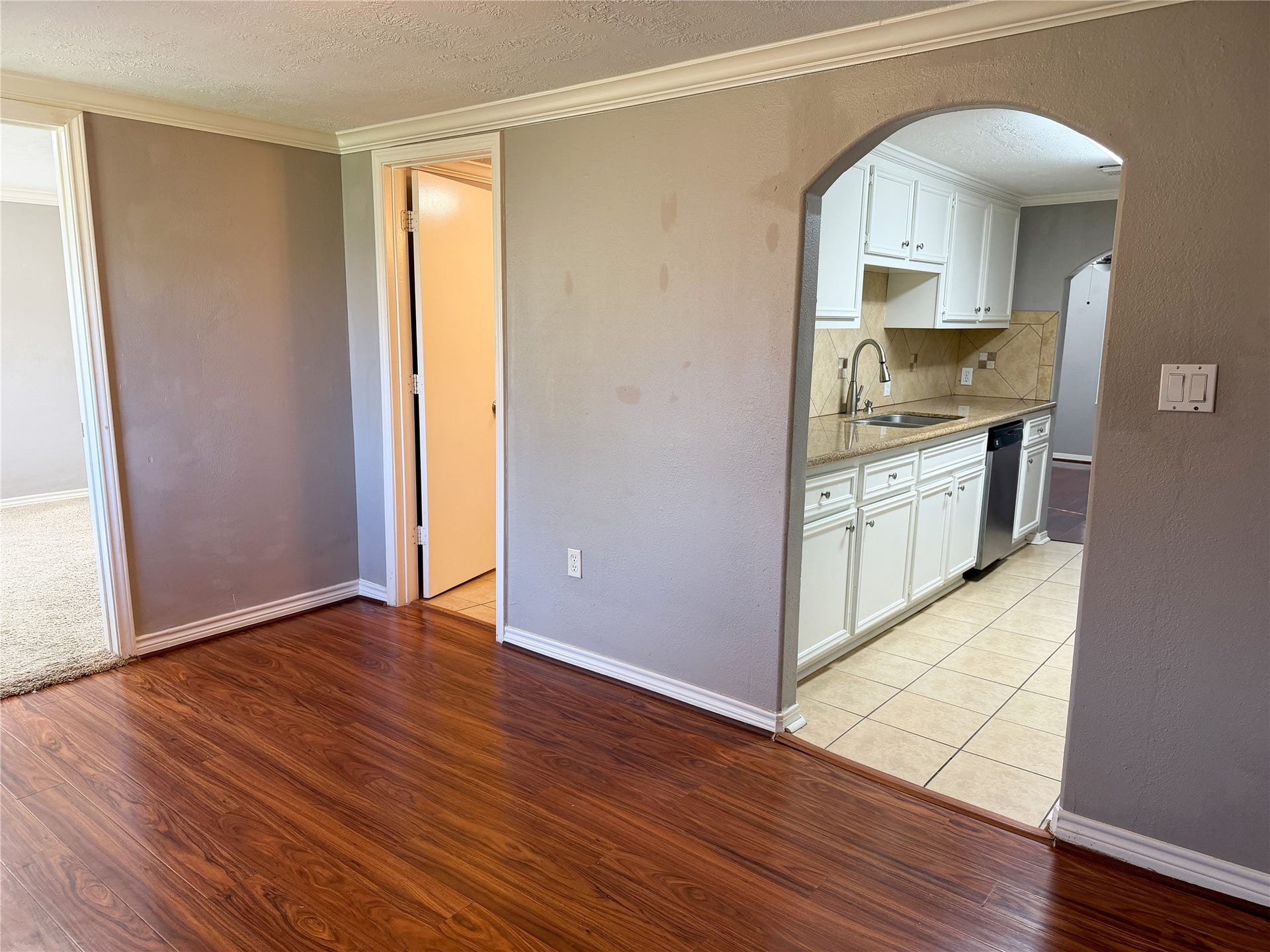 1302 N Avenue R, Freeport, TX 77541 Versatile front room with laminate flooring serves as a central transition space connecting to multiple areas of the home.