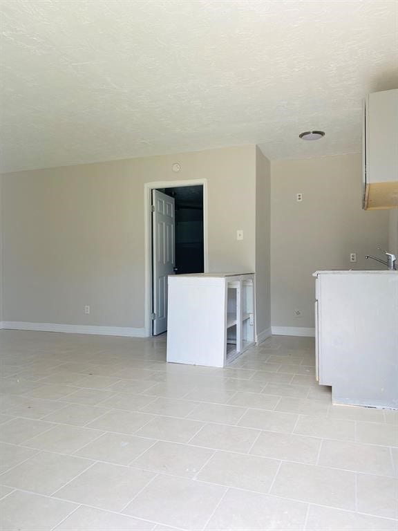 3406 Daphne St Street, #5, Houston, TX 77021 Bright and open interior with neutral tones, tile flooring, and a partially finished kitchen, offering a blank canvas for customization.