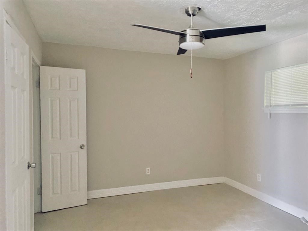 3406 Daphne St Street, #5, Houston, TX 77021 Bright and inviting room featuring neutral walls, tiled flooring, a modern ceiling fan, and ample natural light from a cozy window.