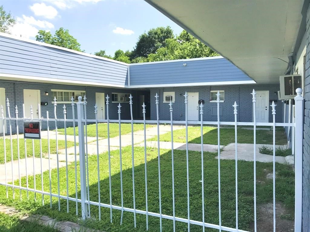 3406 Daphne St Street, #5, Houston, TX 77021 Charming single-story property with a modern blue exterior, nestled behind a decorative white fence, offering privacy and a welcoming atmosphere.