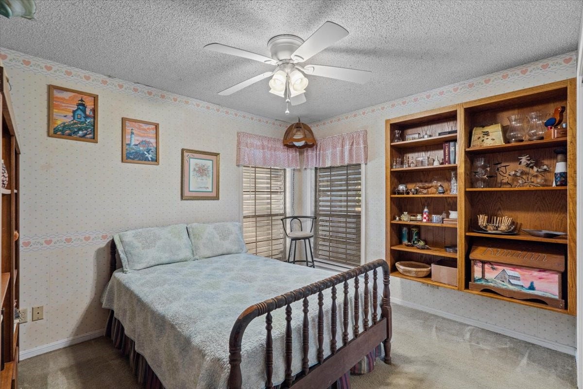 8717 Acorn Lane, Hitchcock, TX 77563 Third bedroom with carpet and shelving.