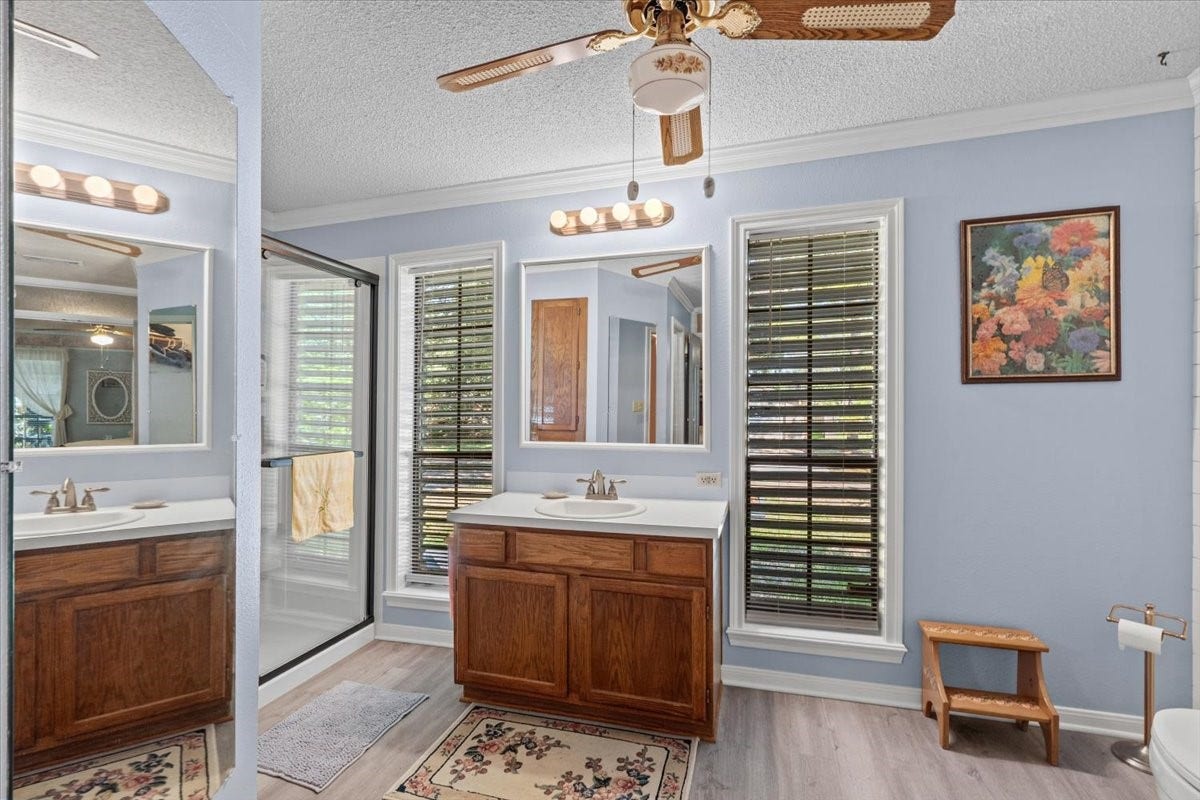 8717 Acorn Lane, Hitchcock, TX 77563 Primary bathroom with vinyl flooring, updated shower and double walk-in closets.