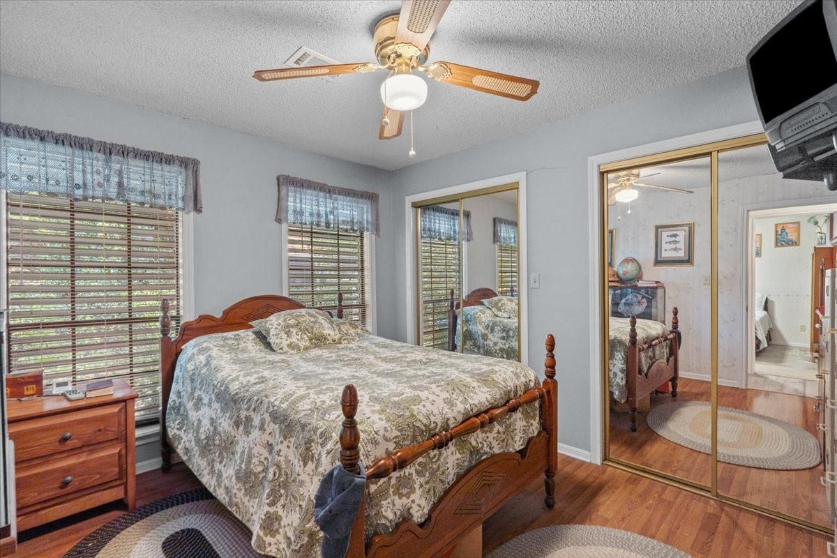 8717 Acorn Lane, Hitchcock, TX 77563 Secondary bedroom with double closets and vinyl flooring.