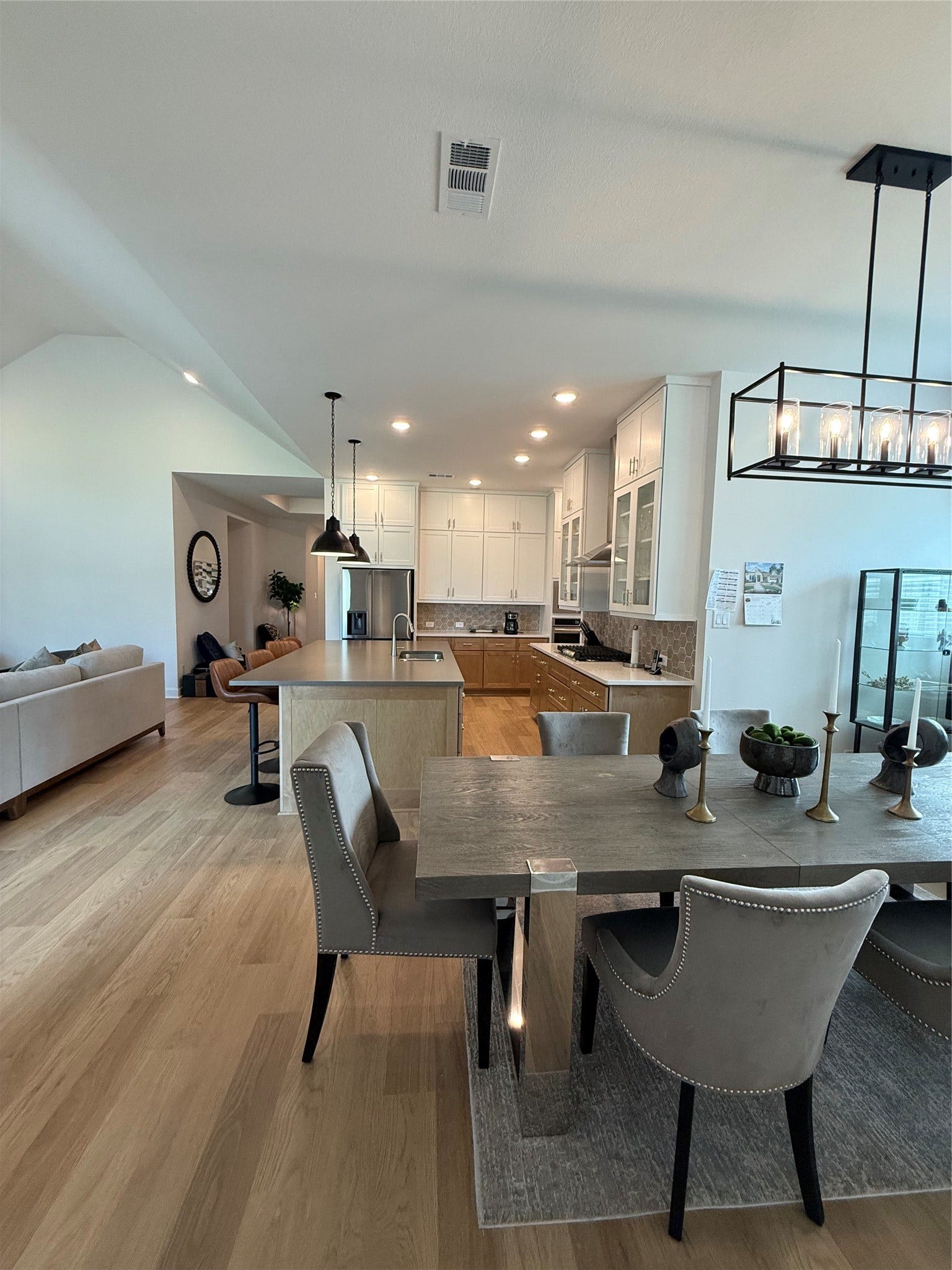 9911 Deep Water Drive, Missouri City, TX 77459 Experience modern elegance in this open-concept living space featuring a stylish kitchen with white cabinetry, a spacious island, and contemporary lighting. Perfect for entertaining, the adjoining dining area seamlessly flows into a cozy living room.