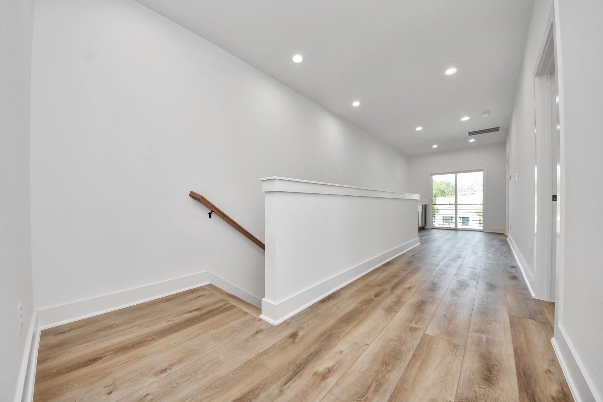 2904 Ruth Street, Houston, TX 77004 Unit B upstairs hallway featuring wood-look flooring and access to the private balcony.