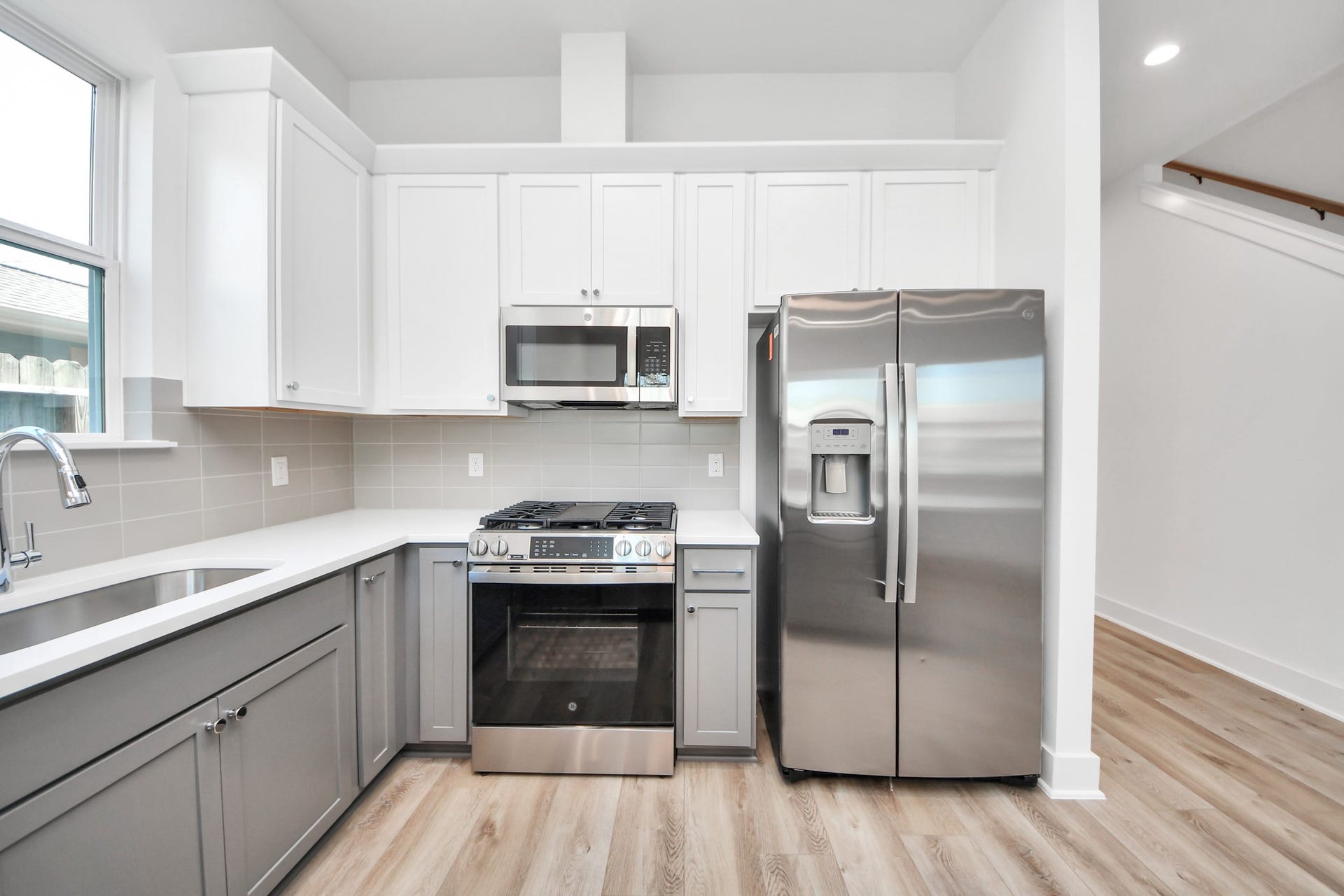 2904 Ruth Street, Houston, TX 77004 Unit B kitchen featuring white cabinetry, gray lower cabinets, and stainless steel appliances.